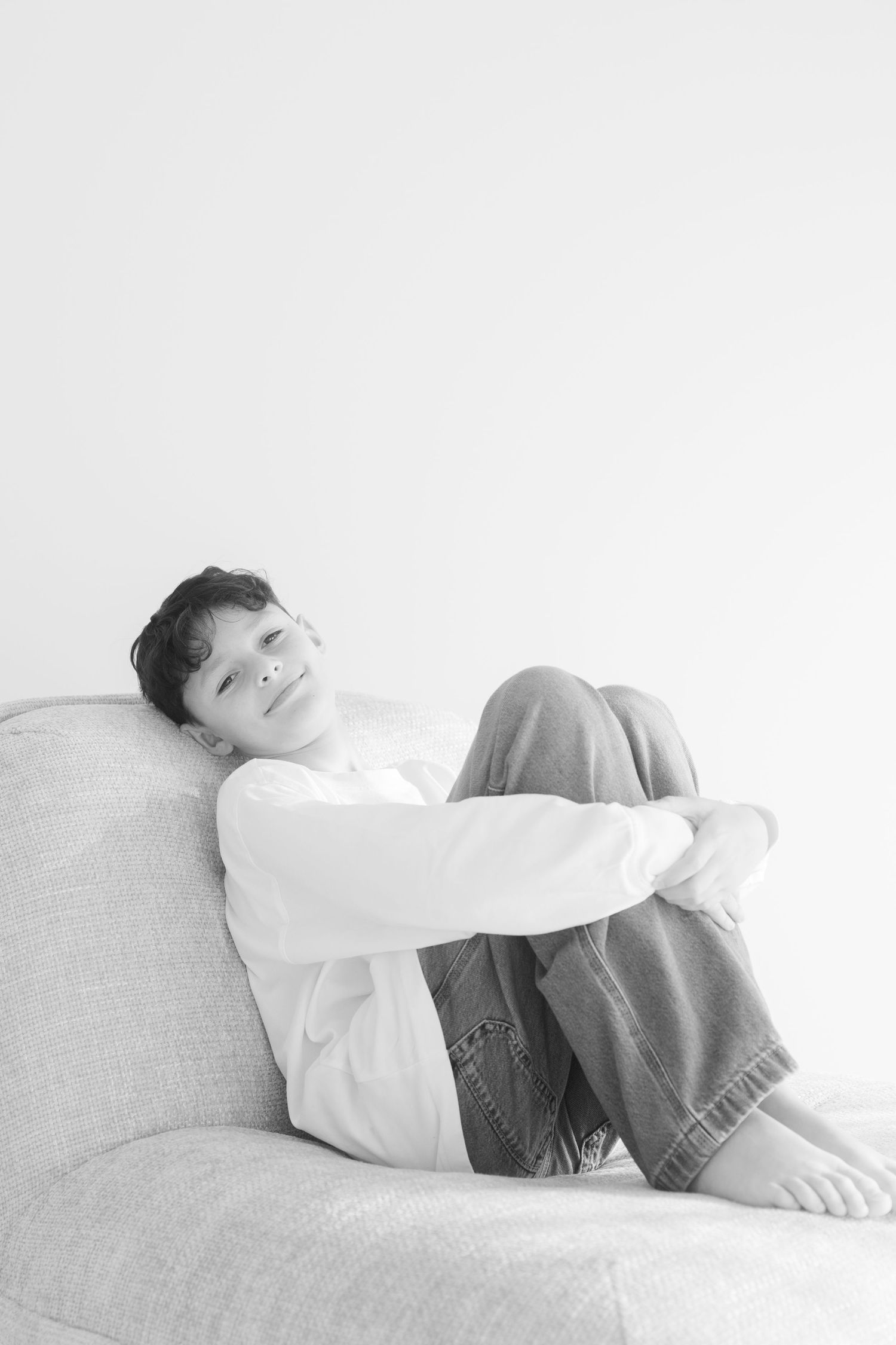 Series of relaxed portraits showing someone resting peacefully on a light gray couch.