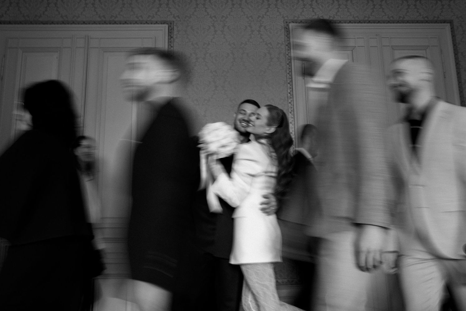 Motion-blurred black and white image of wedding reception dancing.