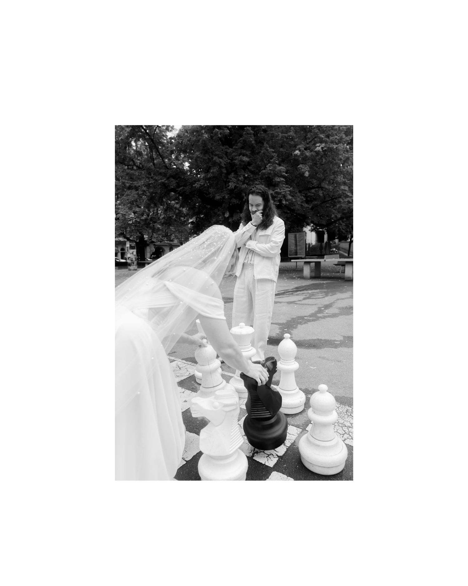 A sequence of five photos showing a person in white attire playing chess with a large outdoor chess set in a park setting.