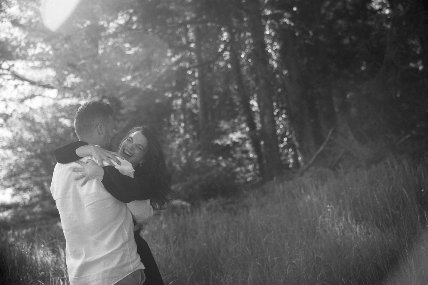 A sequence of black and white photographs showing someone dancing in a grassy meadow with trees in the background.