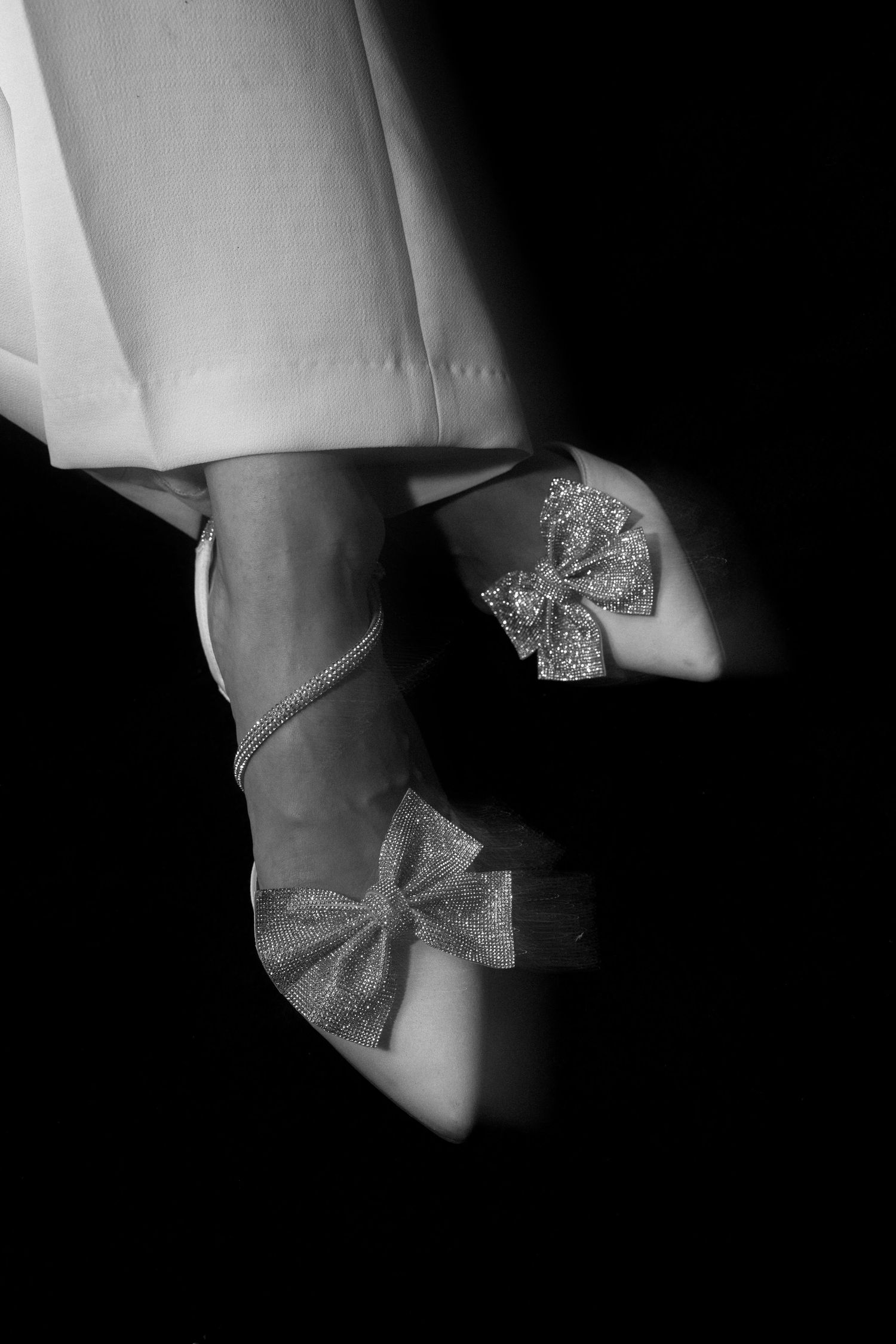 Close-up of sparkly bow detail on elegant bridal shoes.