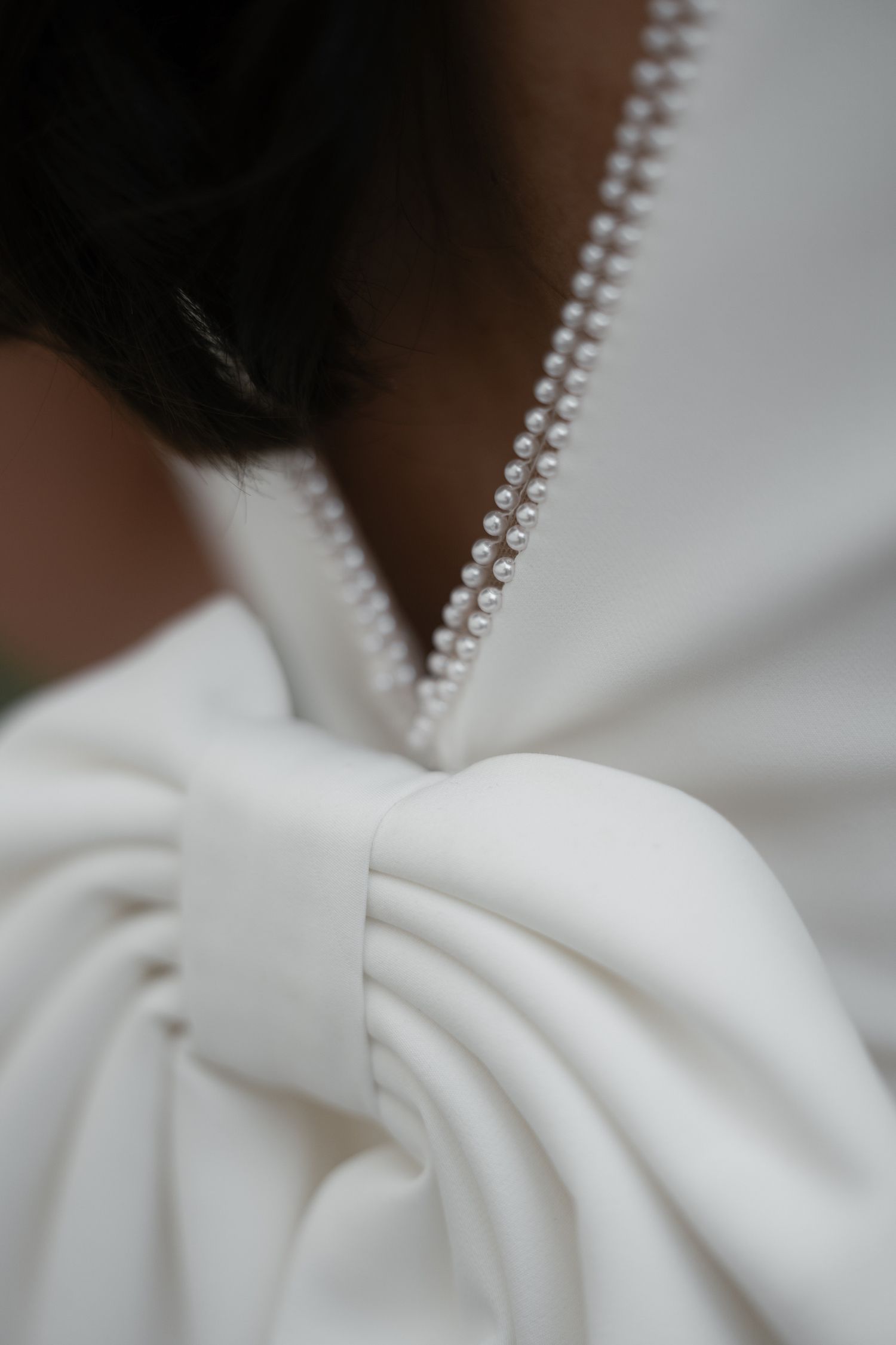 Close-up detail of white fabric with decorative zipper trim at Küssnacht am Rigi