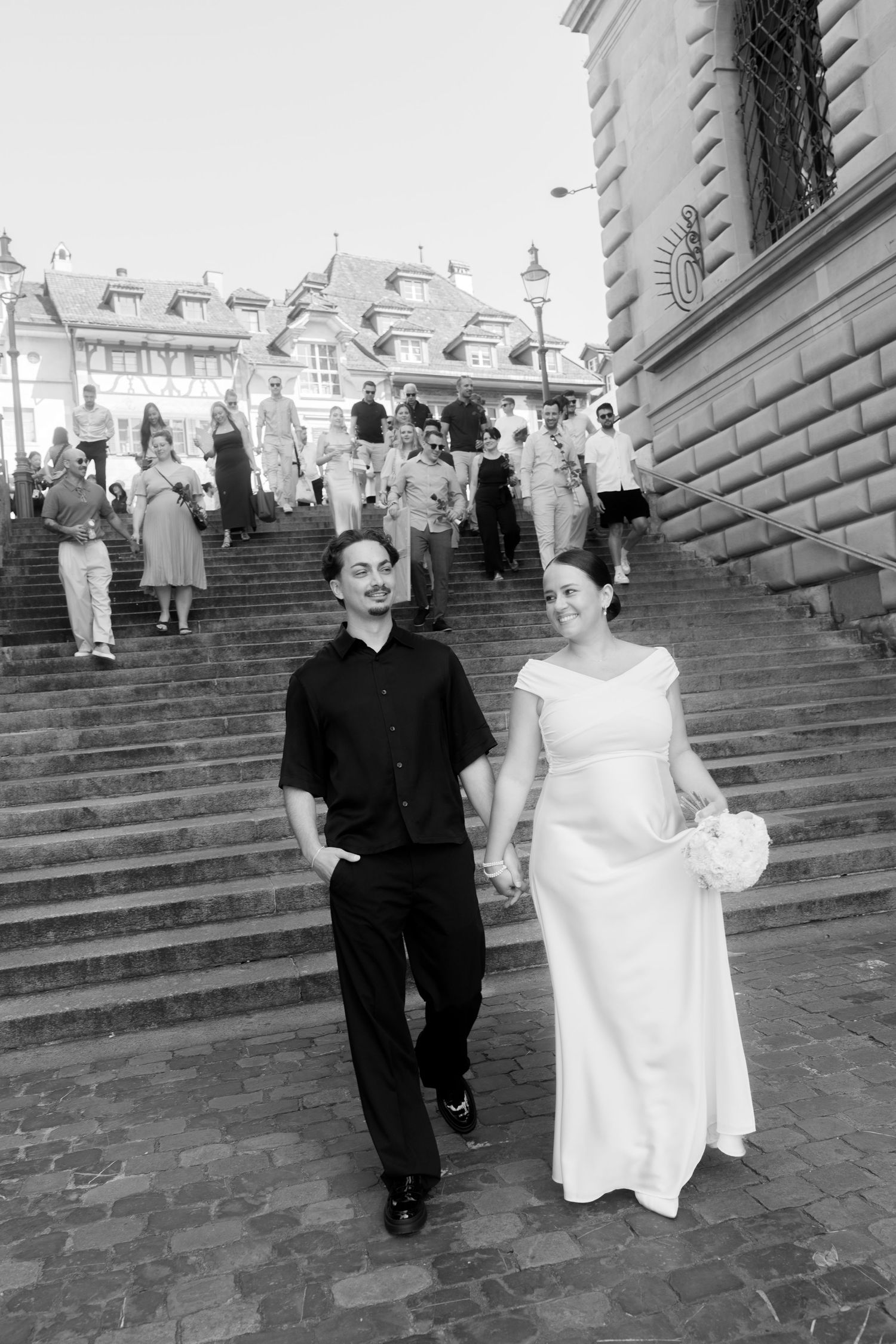 Couple descending grand stone steps in black and white photography.