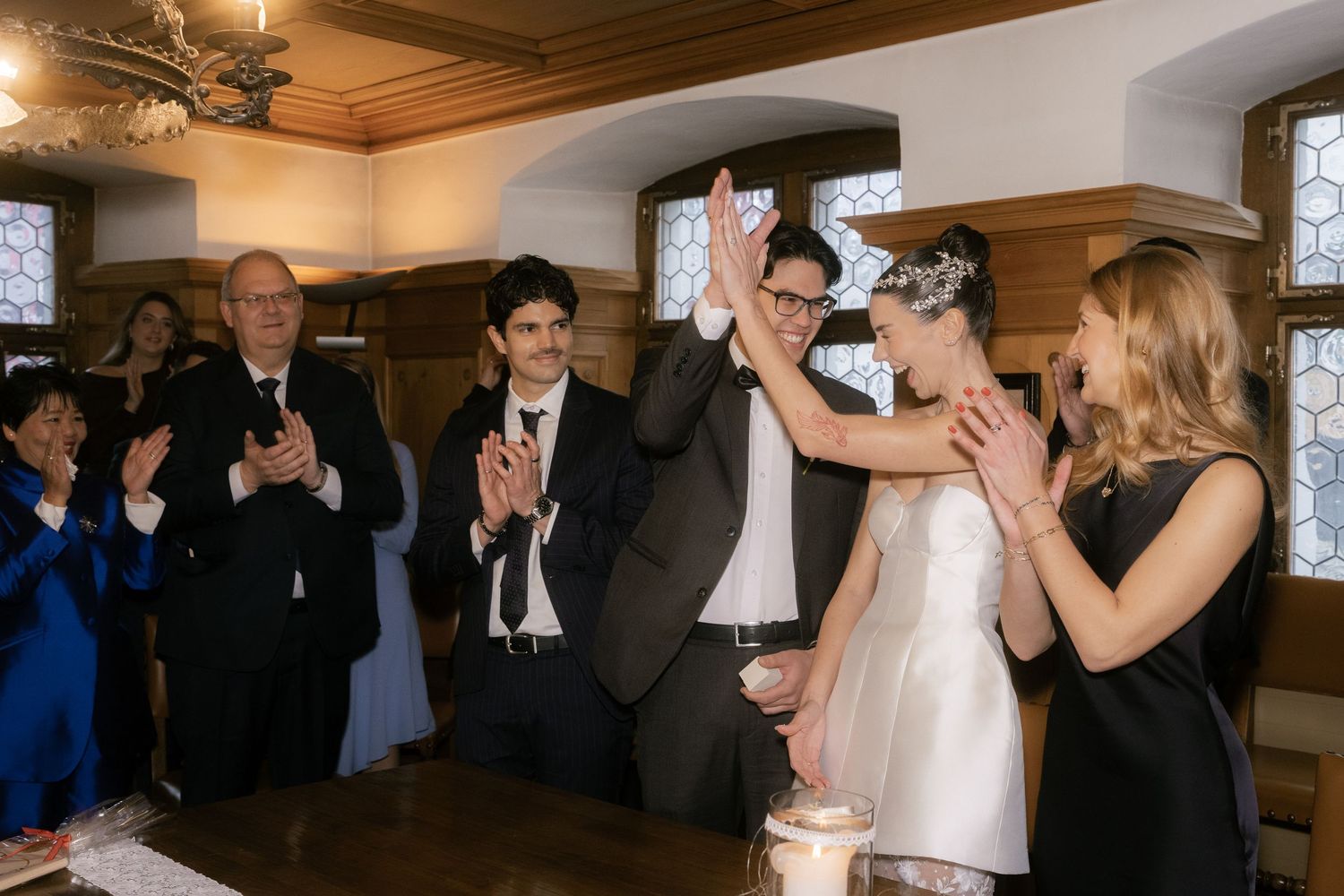 Wedding guests dancing and celebrating together on a wooden dance floor during a reception celebration.