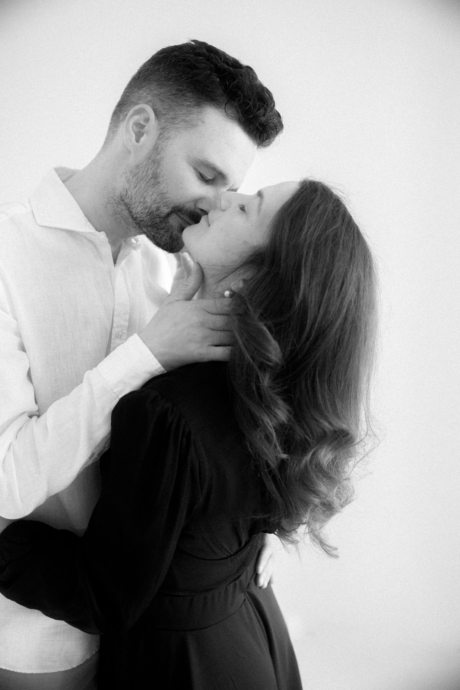 A romantic black and white photo series showing tender moments between a couple in intimate poses against a white background.