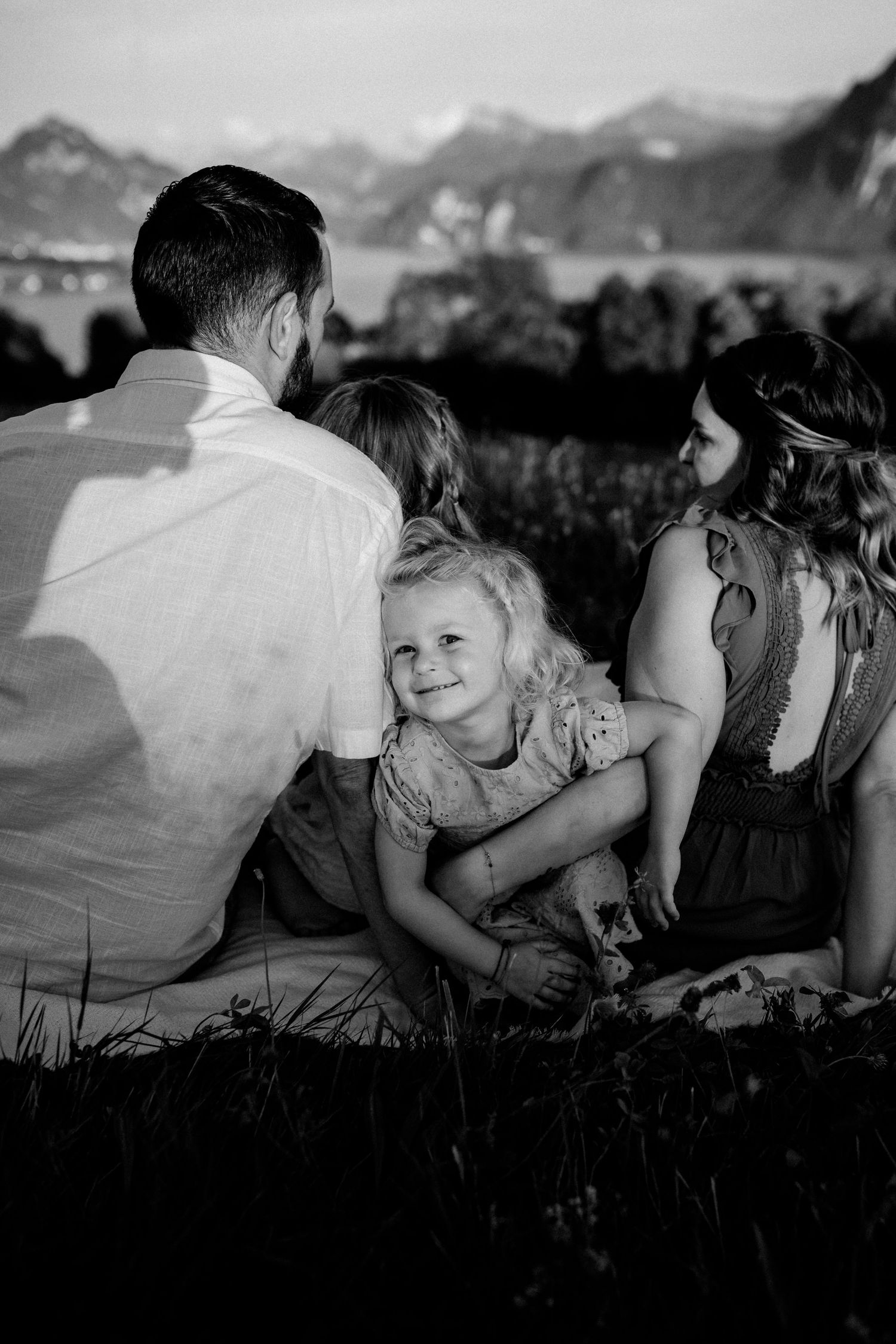 Black and white family photos showing playful moments against a mountain landscape.