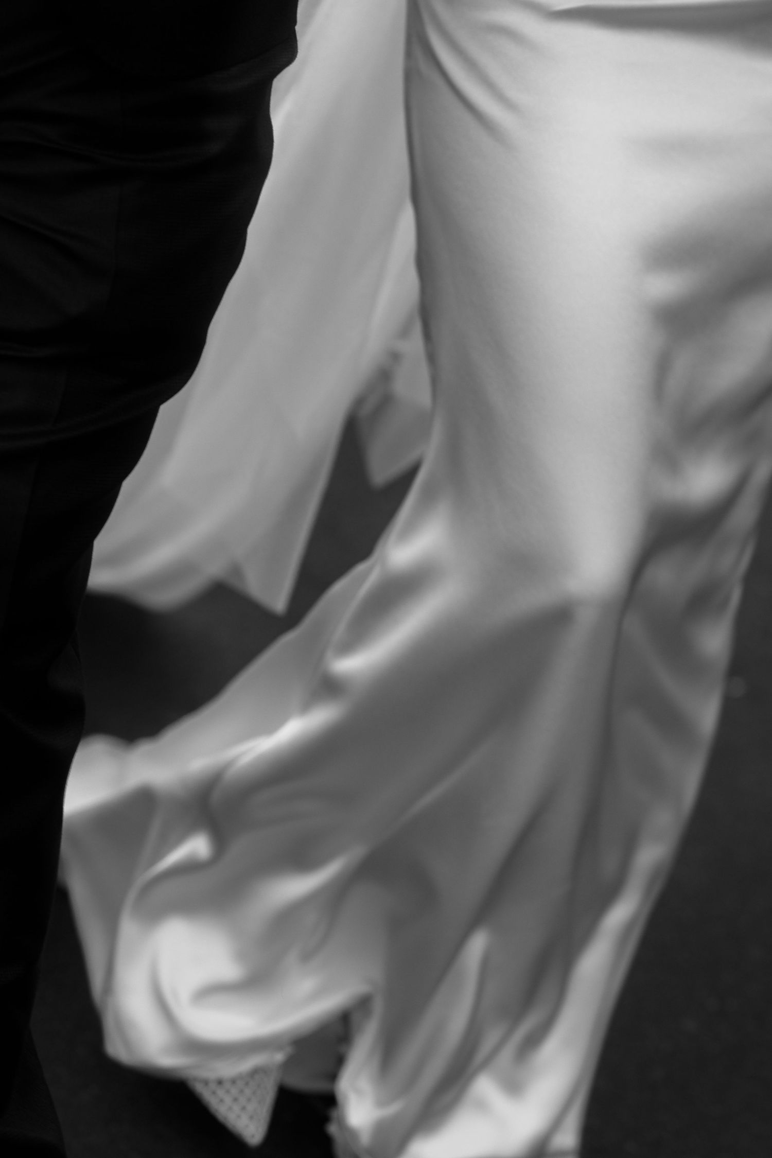 Abstract close-up details of flowing white wedding dress fabric.
