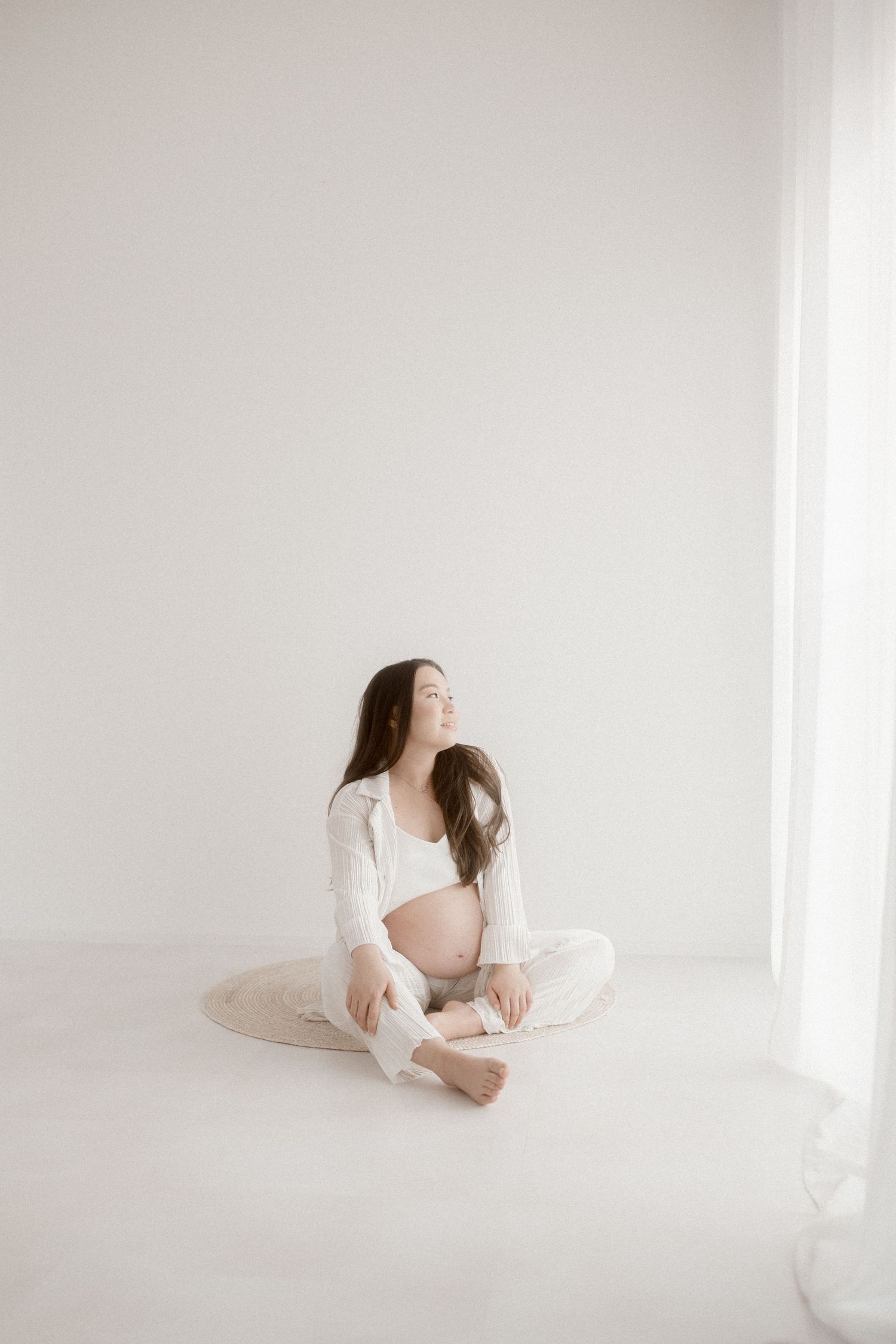 Ethereal portrait series in white dress against minimalist bright background.