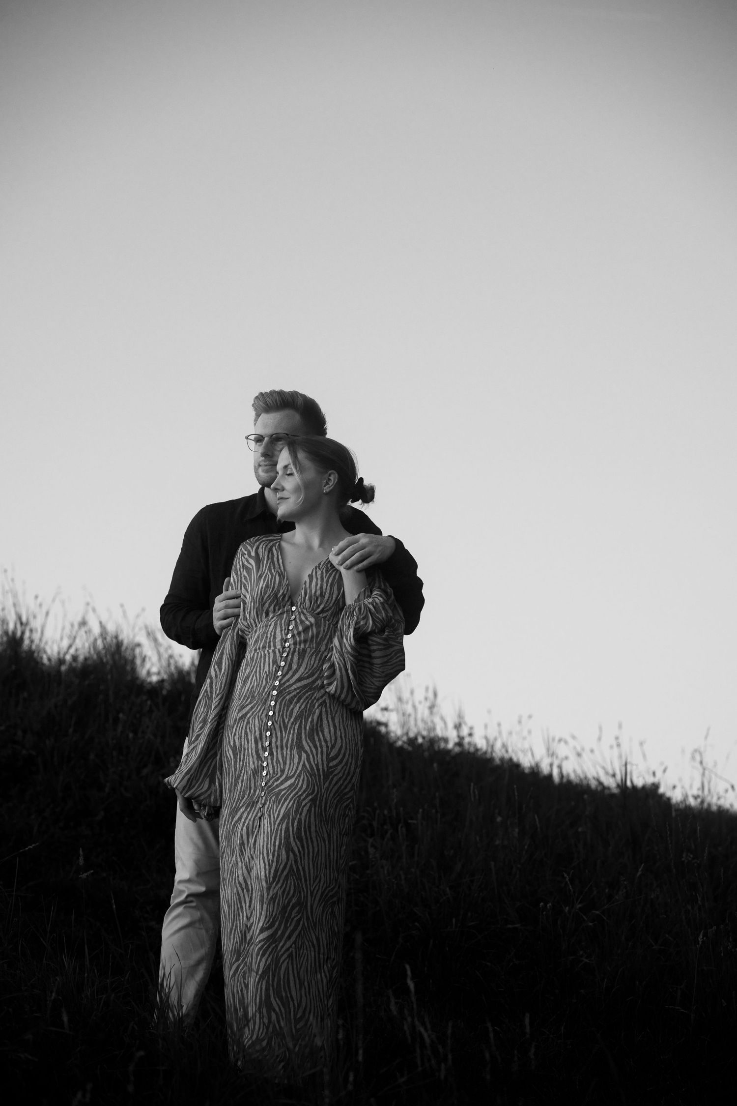 A series of black and white photographs showing a figure in a textured sweater looking up at the sky against a dark background.
