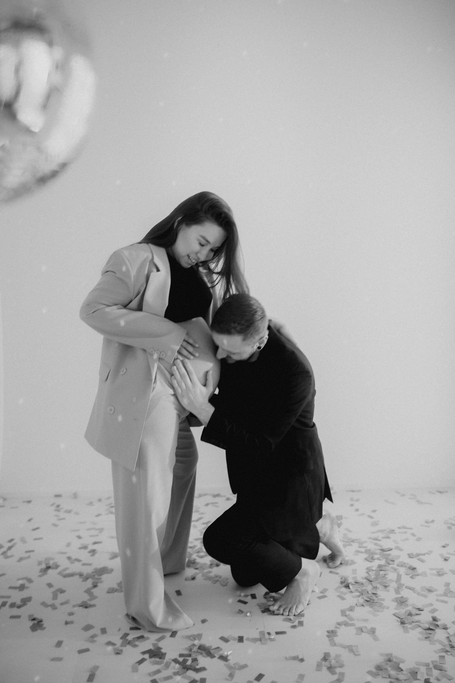 Artistic black and white photo series showing couple interacting on a white floor with scattered petals.