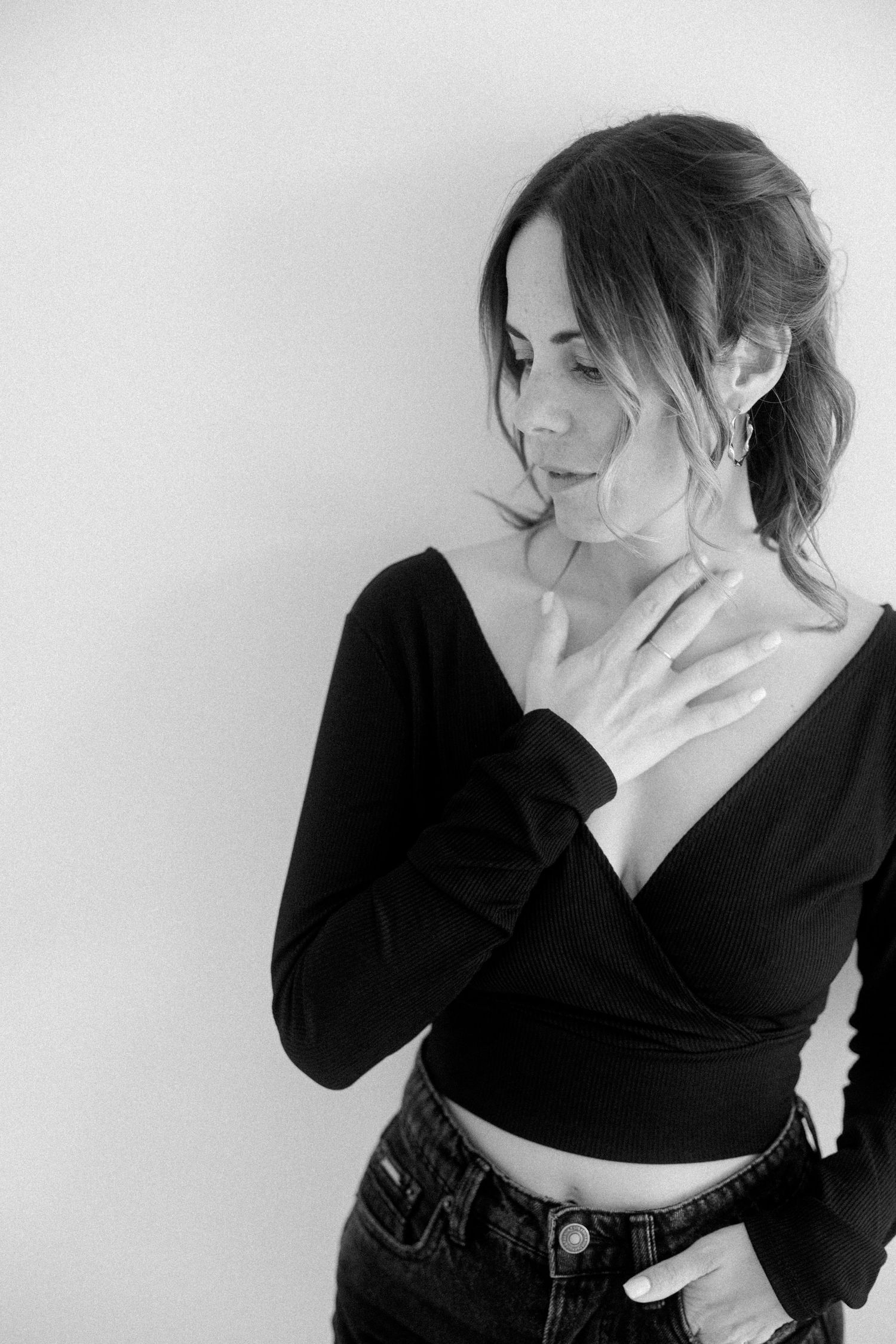 Black and white photo series showing artistic poses in a black wrap top against white background.