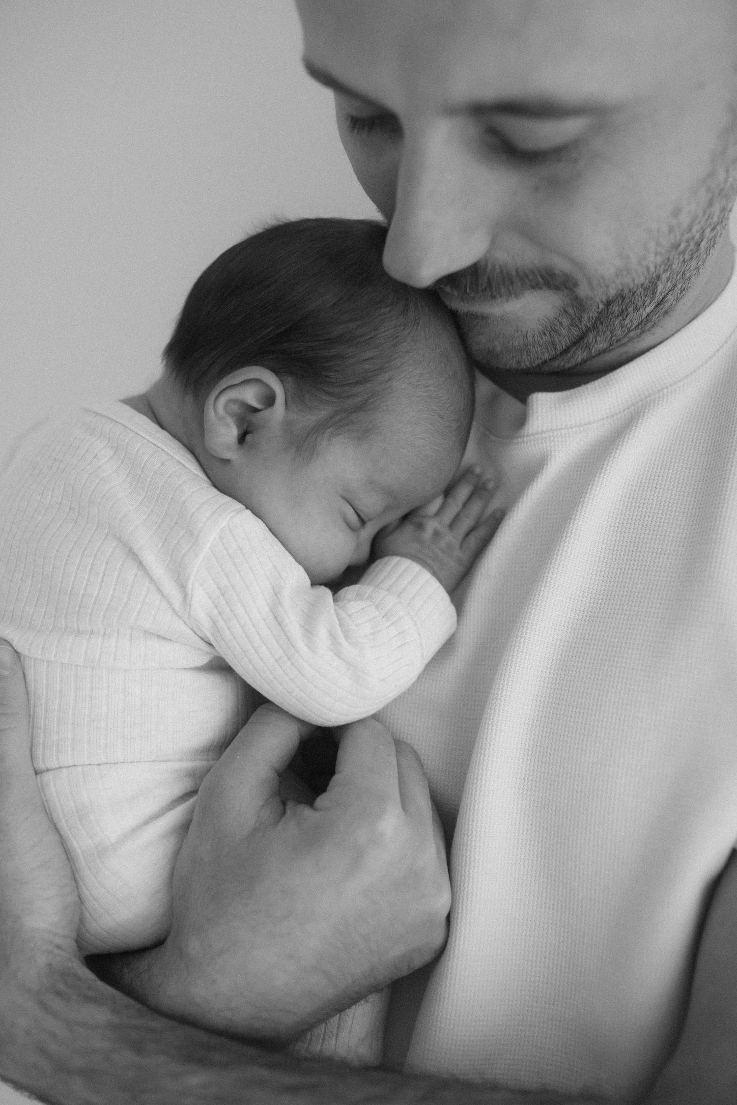 Intimate black and white portraits showing gentle parent-child bonding moments.