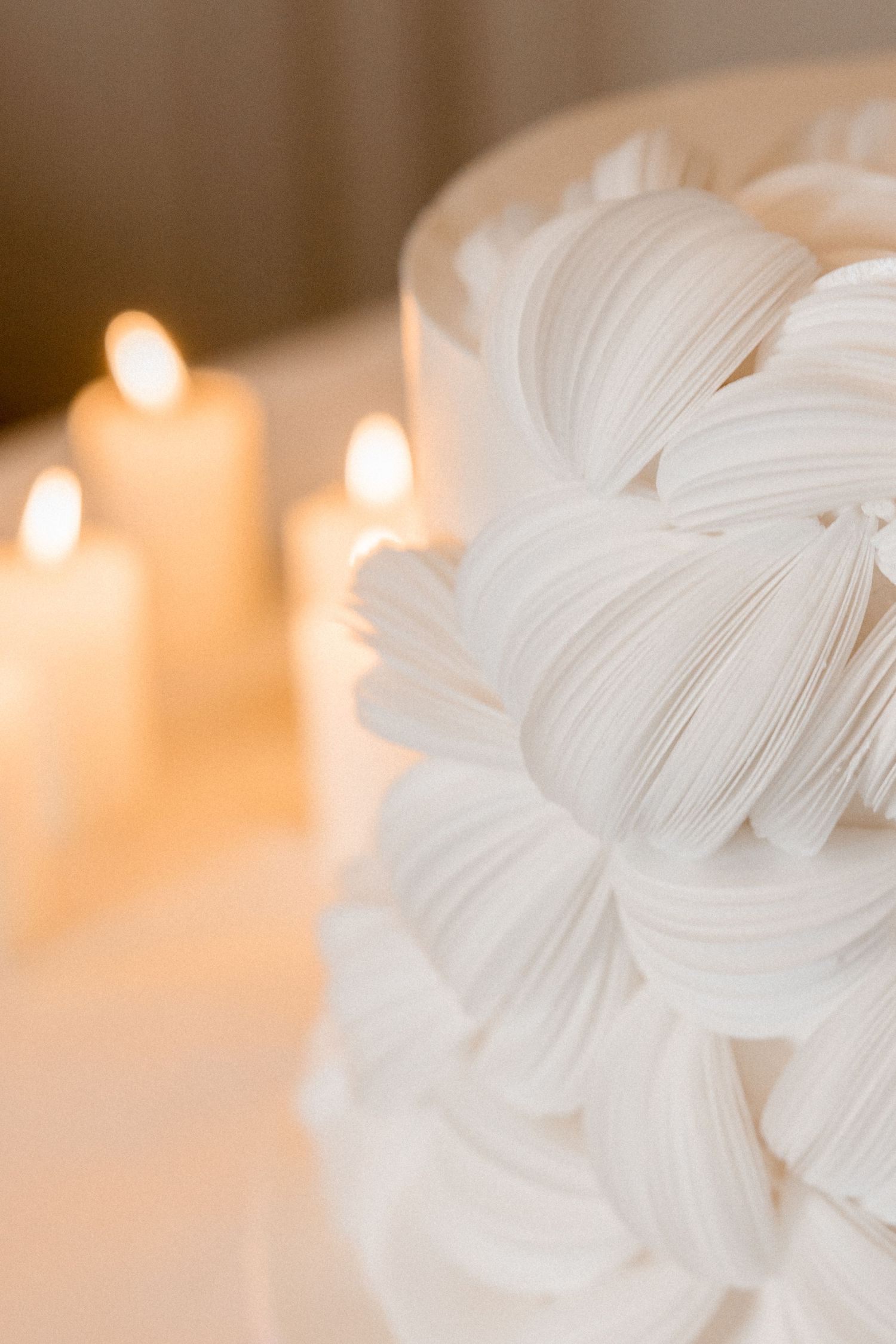Soft white fabric details and delicate textures create an ethereal wedding backdrop illuminated by warm candlelight at Villa Villette Cham.