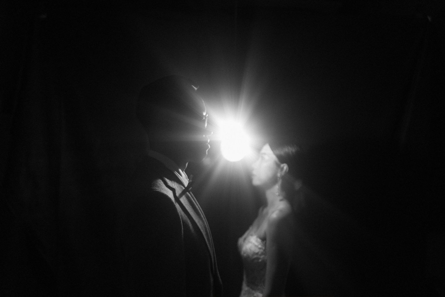 Dramatic silhouette of figures backlit by bright light with smoky atmosphere.