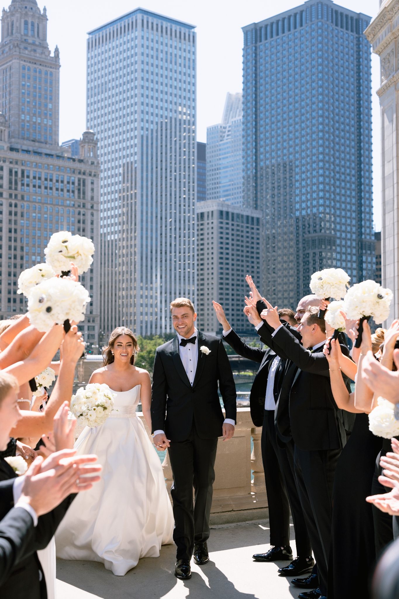 Stylish bride and groom walking through their bridal party in downtown Chicago, captured by Chicago fine art luxury wedding photographer.