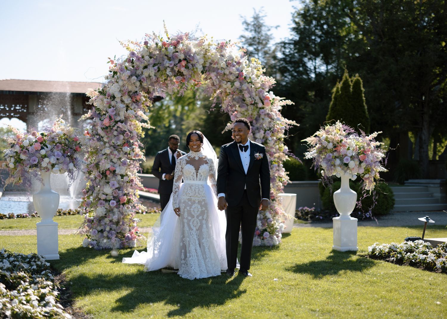 Romantic moment of couple during wedding ceremony under lavish flower arch at Armour House, photographed by luxury Chicago photographer.