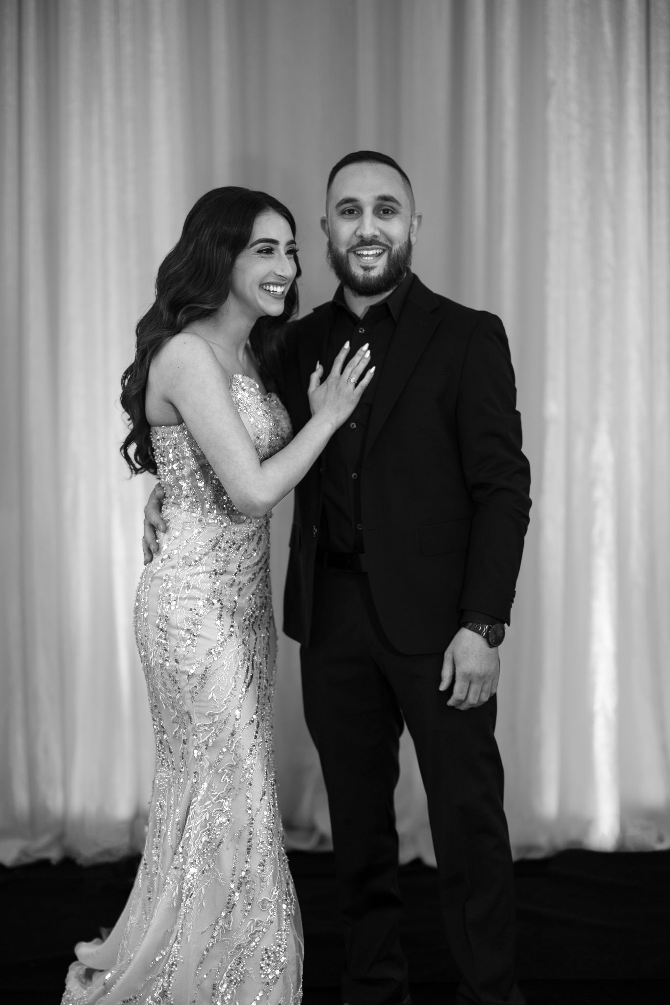 Luxury Chicago wedding photo of stylish bride and groom. Bride is in a sparkly designer dress for the reception showing her engagement ring.