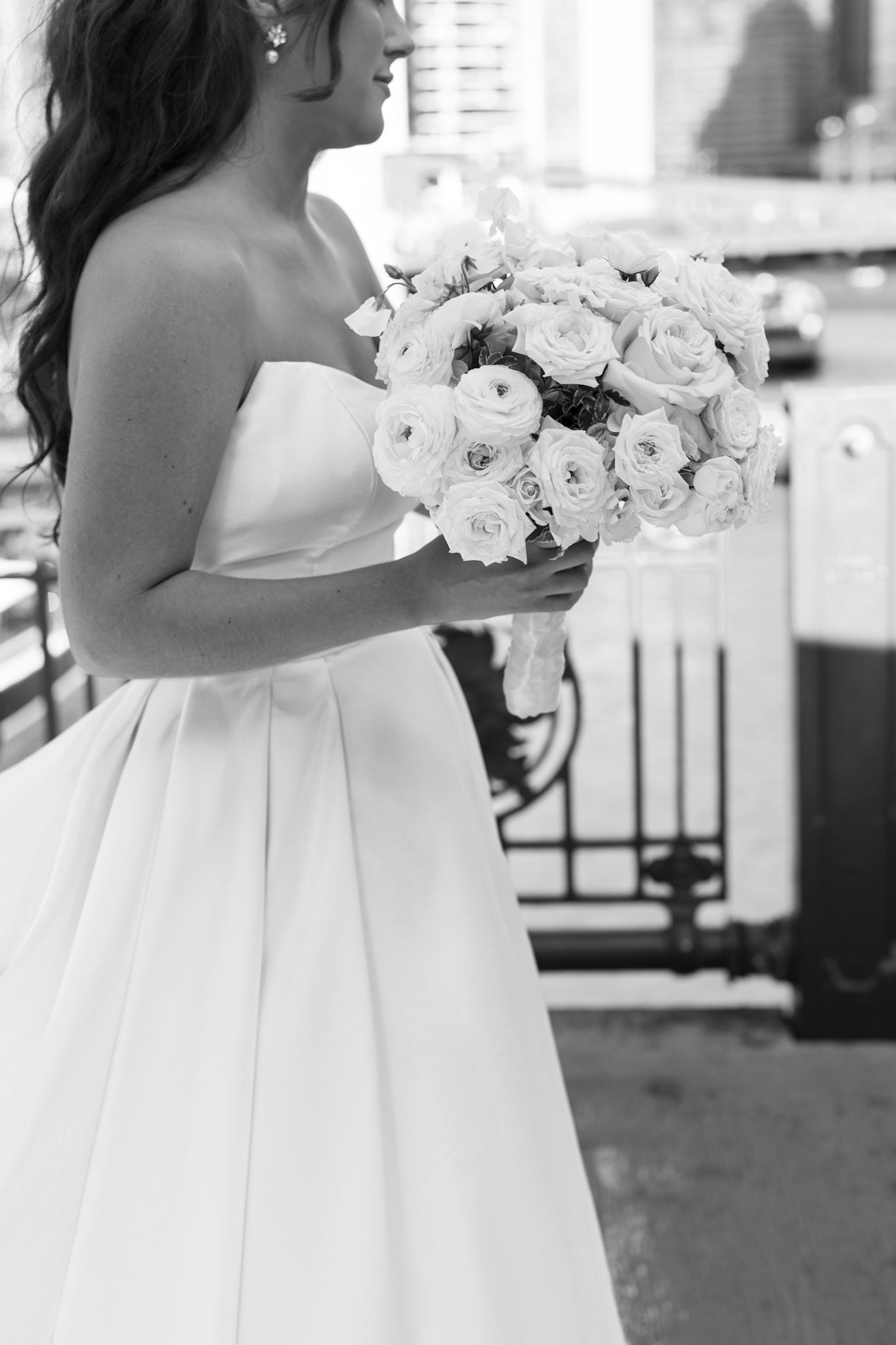 Photo of bride holding elegant bouquet on Chicago bridge, captured by luxury photographer specializing in documentary wedding photography.