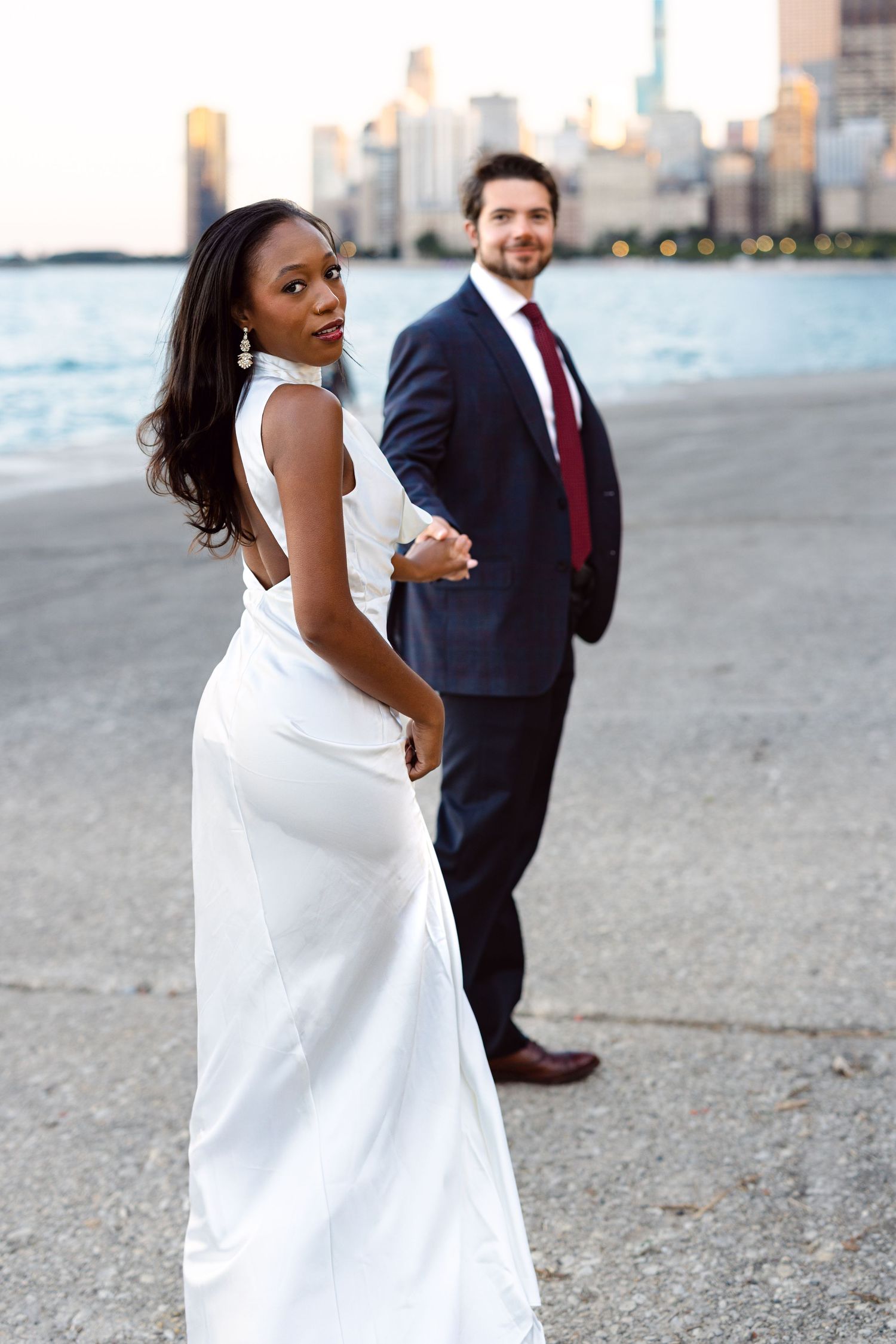 Engaged couple at North Avenue Beach in Chicago with skyline views. Modern engagement photos featured by the Art Institute of Chicago.