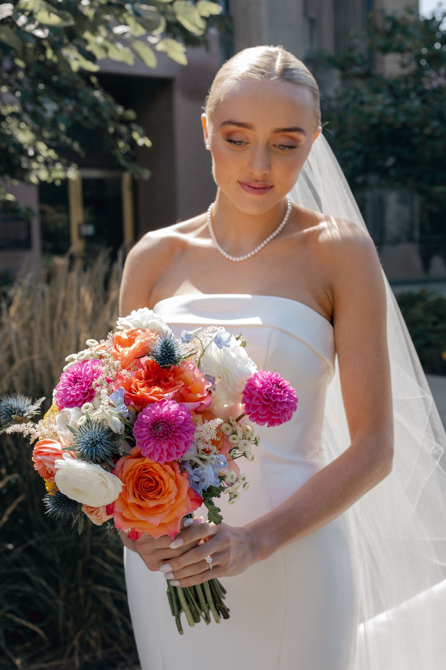 Luxury Chicago photographer captures bride looking at bouquet at Loyola Evanston, specializing in editorial and candid wedding photography.