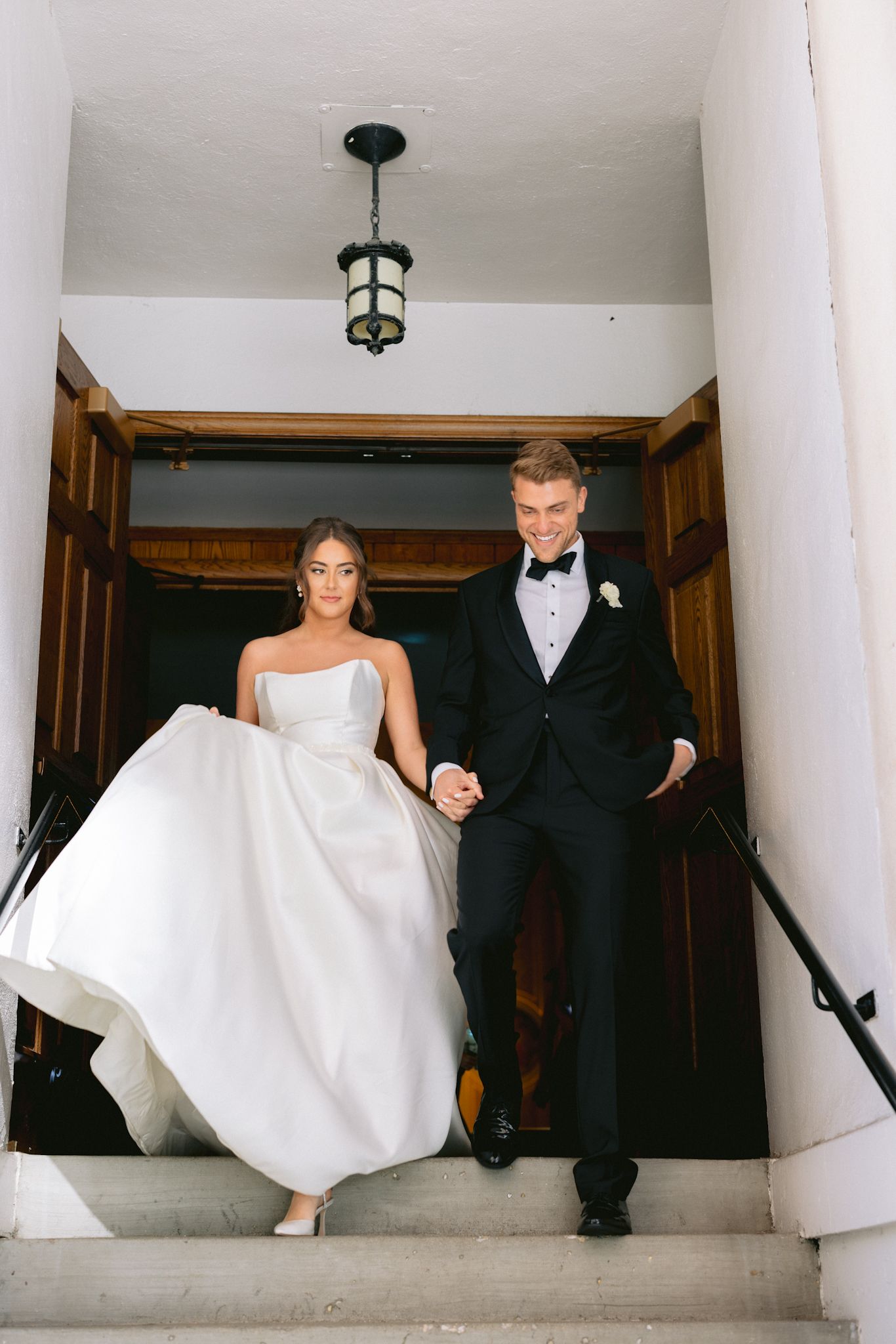 Just married couple walking down the steps of Assumption Catholic Church Chicago, photographed by a luxury Chicago wedding photographer.