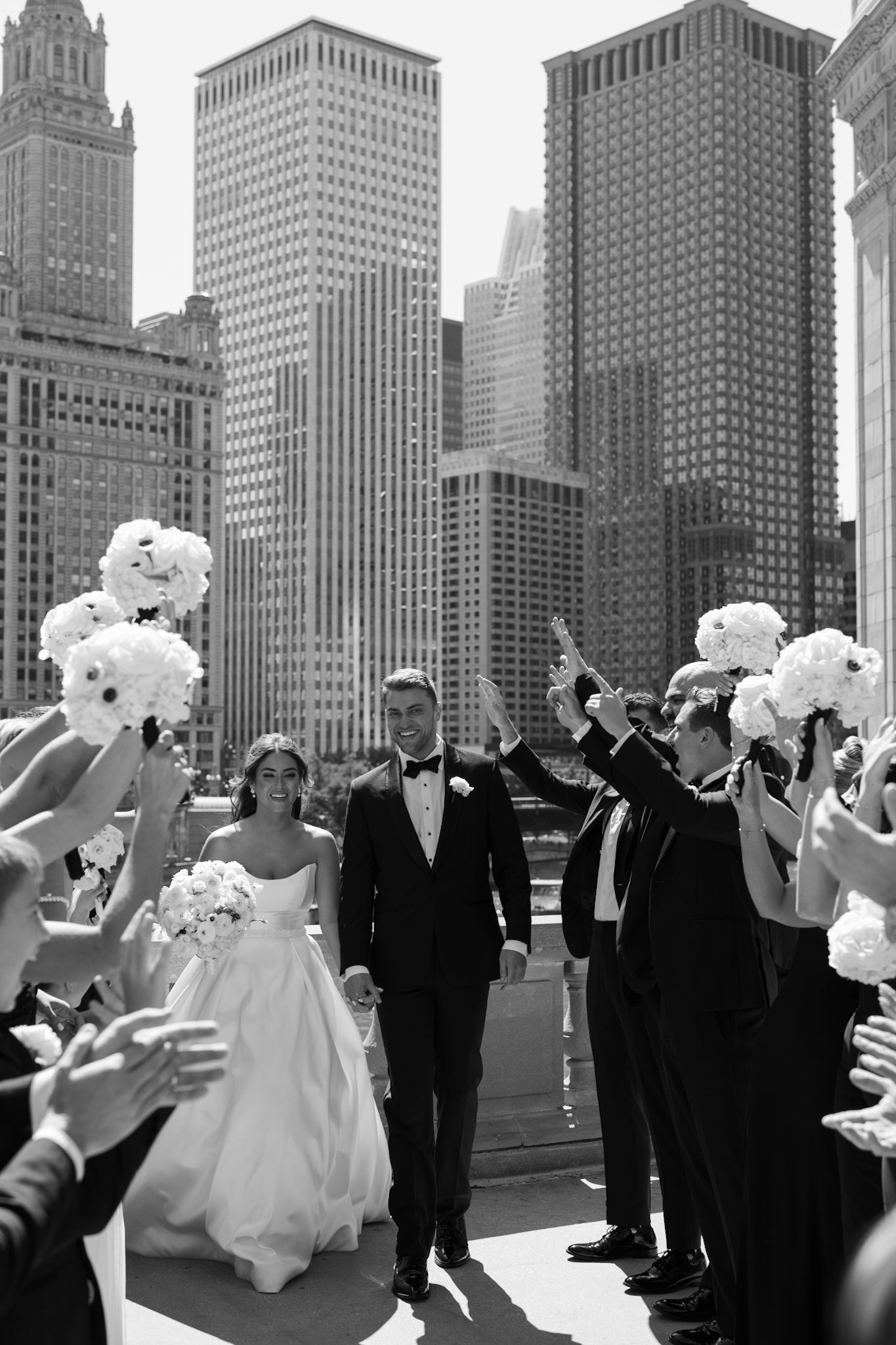 Candid moment of styled bride and groom walking through bridal party, perfect wedding photography captured by Chicago-based photographer.