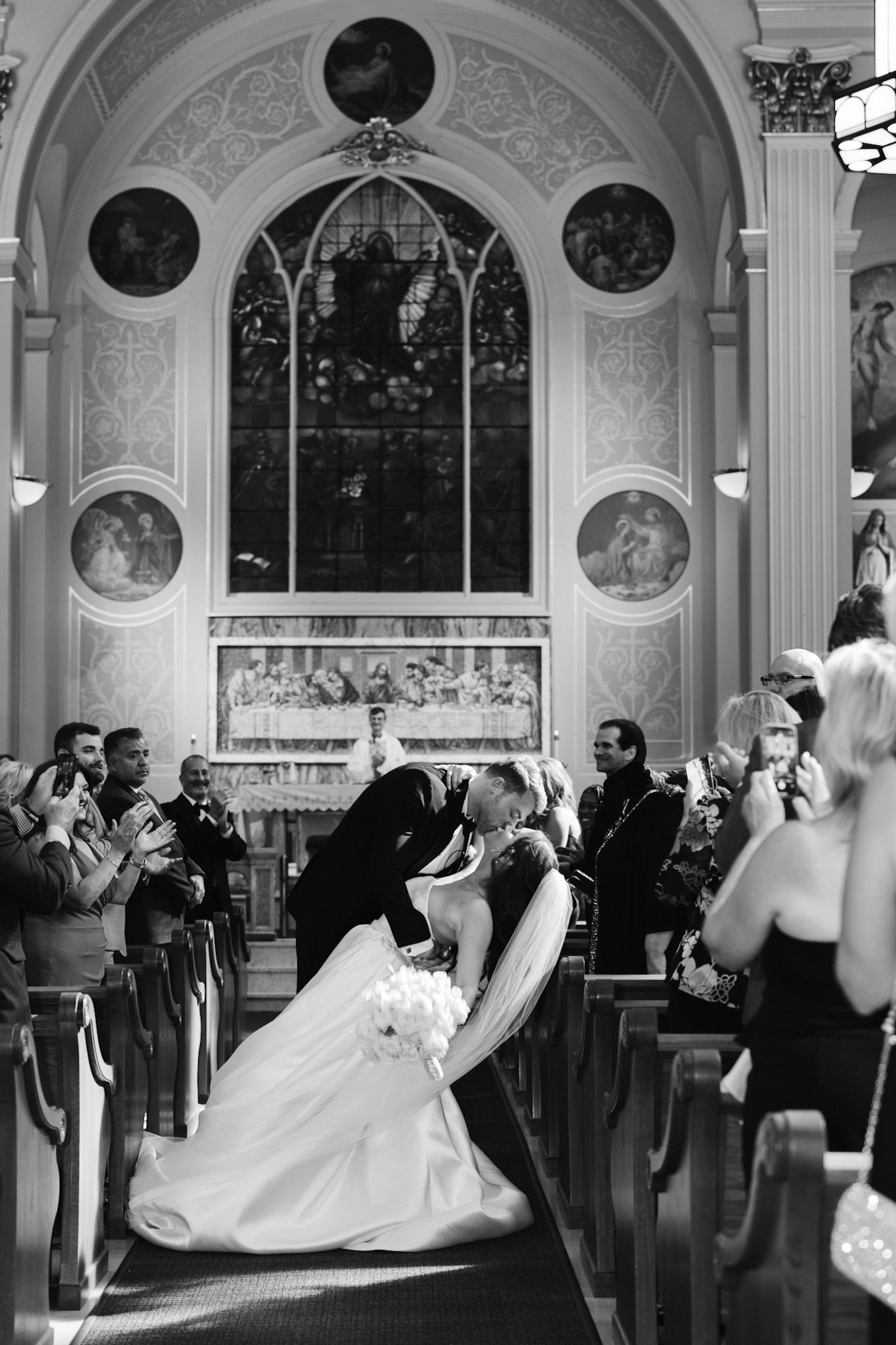 Groom dips bride during candid wedding at Assumption Catholic Church, photographed in documentary style by Chicago luxury photographer.
