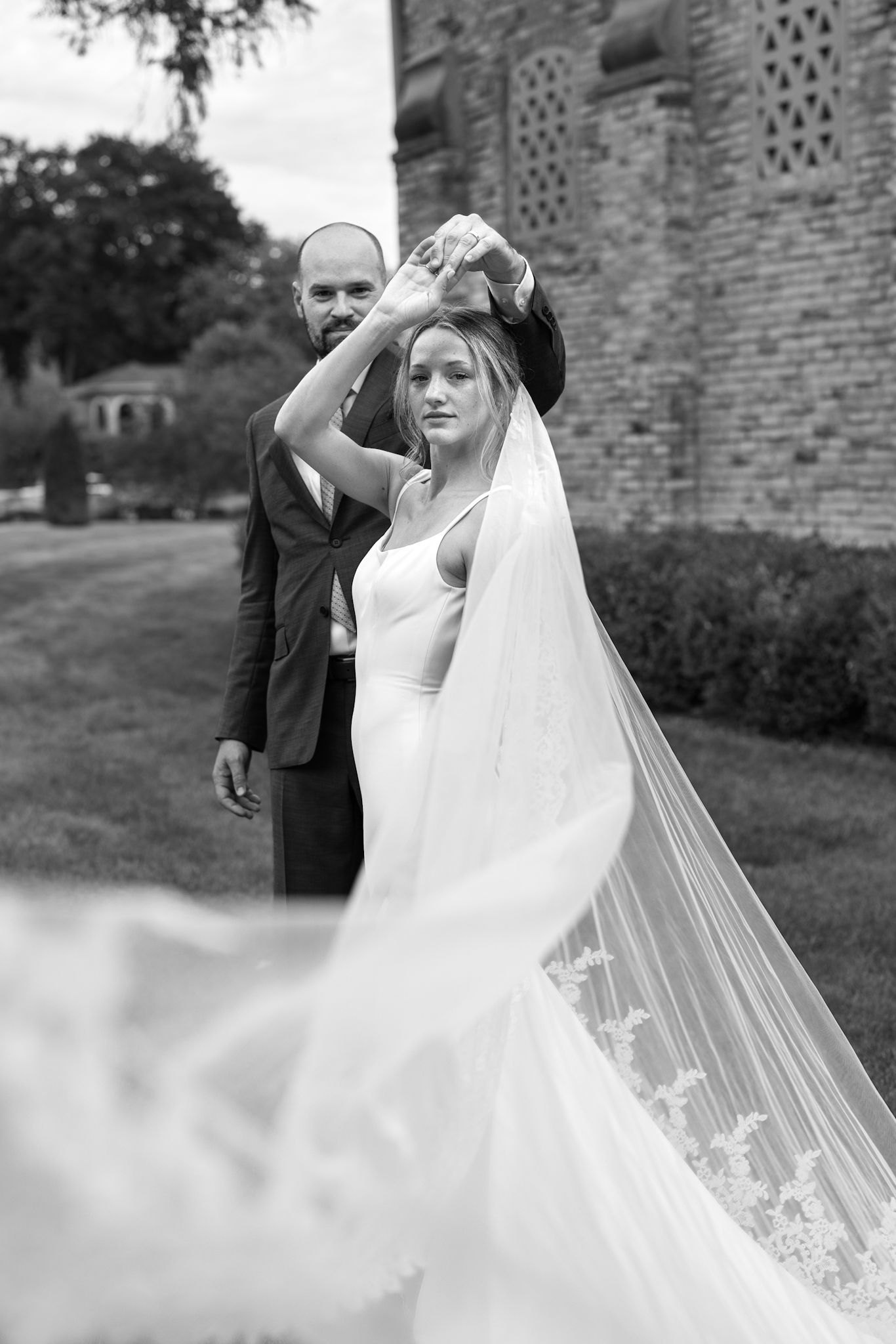 Bride with groom in designer Steven Khalil cathedral Poppy veil, captured by Chicago and destination luxury wedding photographer downtown.