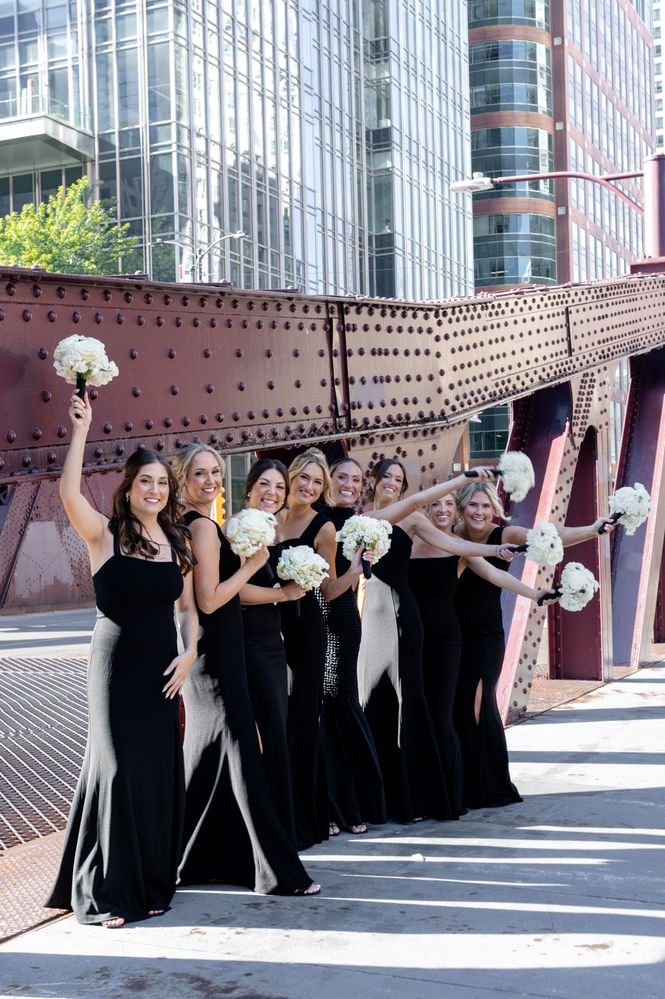 Bridesmaids with bouquets on a Chicago bridge, photographed in a documentary and editorial style by a luxury Chicago wedding photographer.