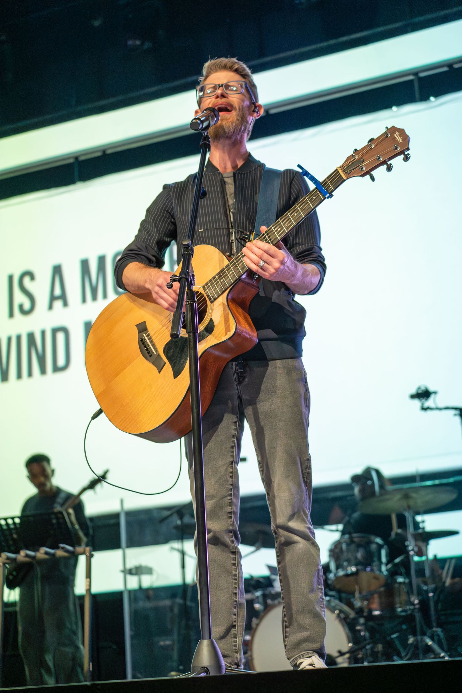 Musician playing guitar on stage during a worship night, event photography