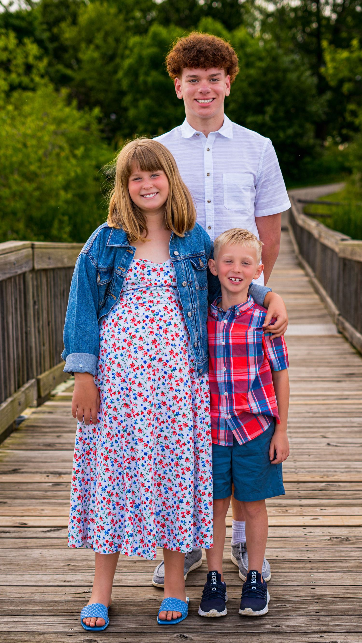 Brother and sister standing together on a wooden bridge, sibling portrait
