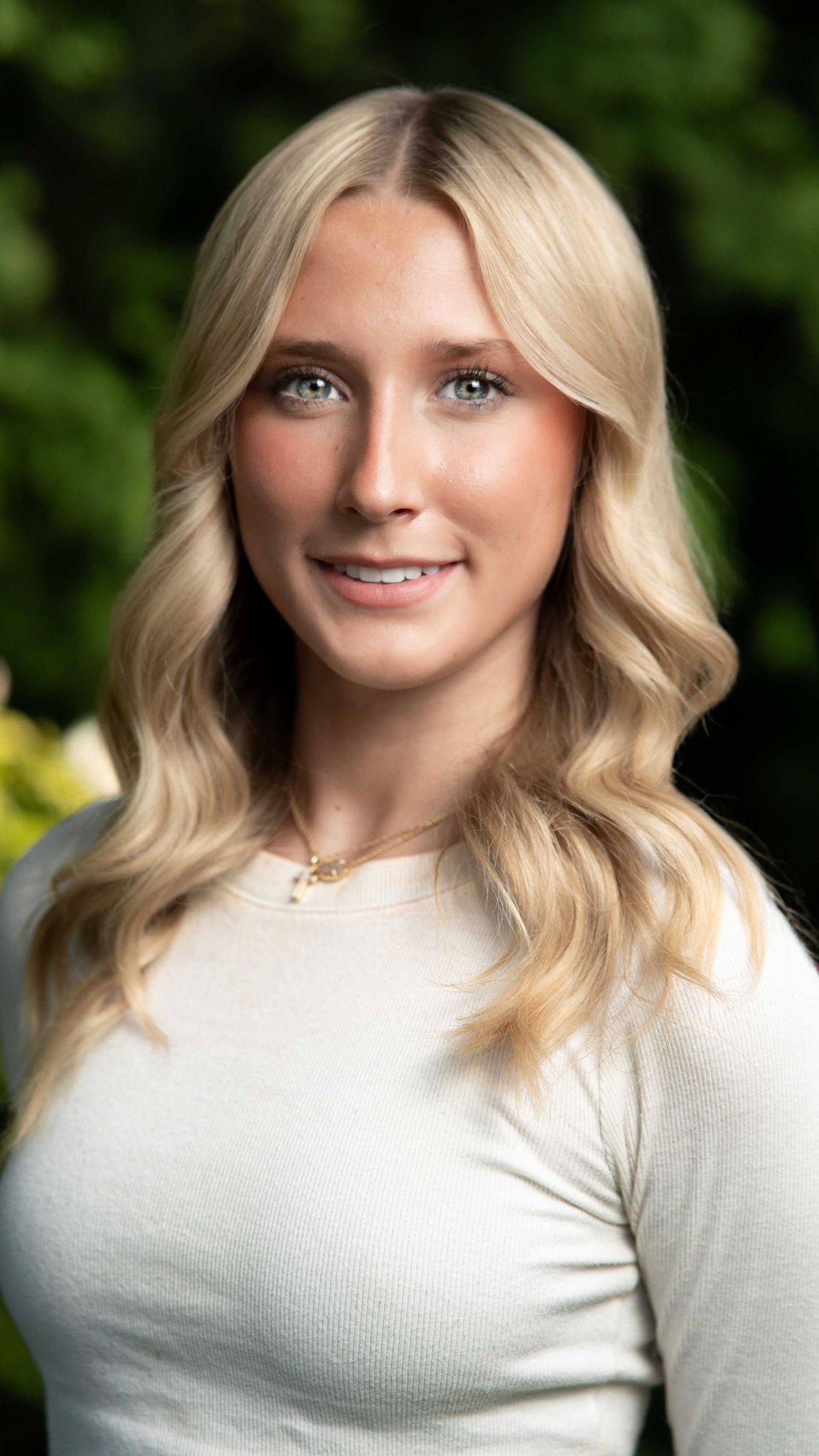 Outdoor senior portrait against a rustic wooden wall