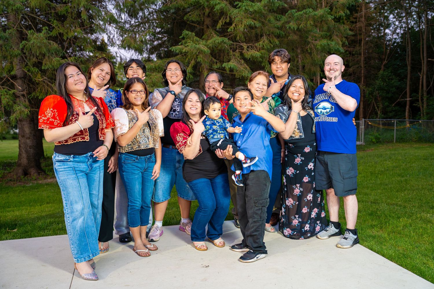 Extended family posing playfully together outdoors, group family photo