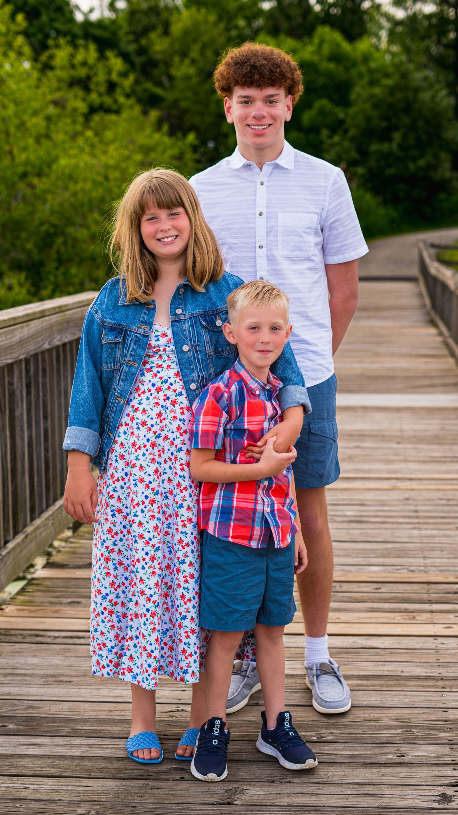 Family of five standing together on a wooden bridge, outdoor family photography