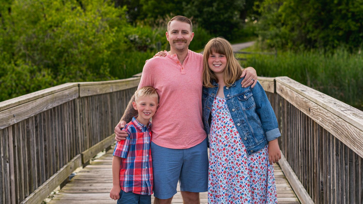 Family walking together on a wooden bridge, outdoor family photography
