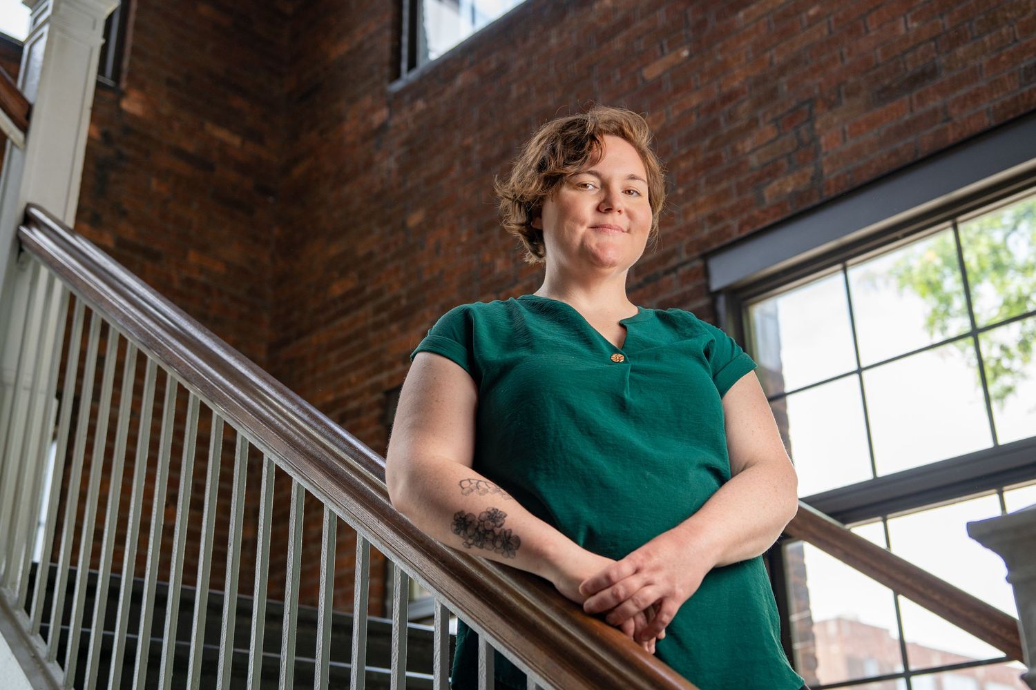 Portrait of a woman in a green top on a brick staircase
