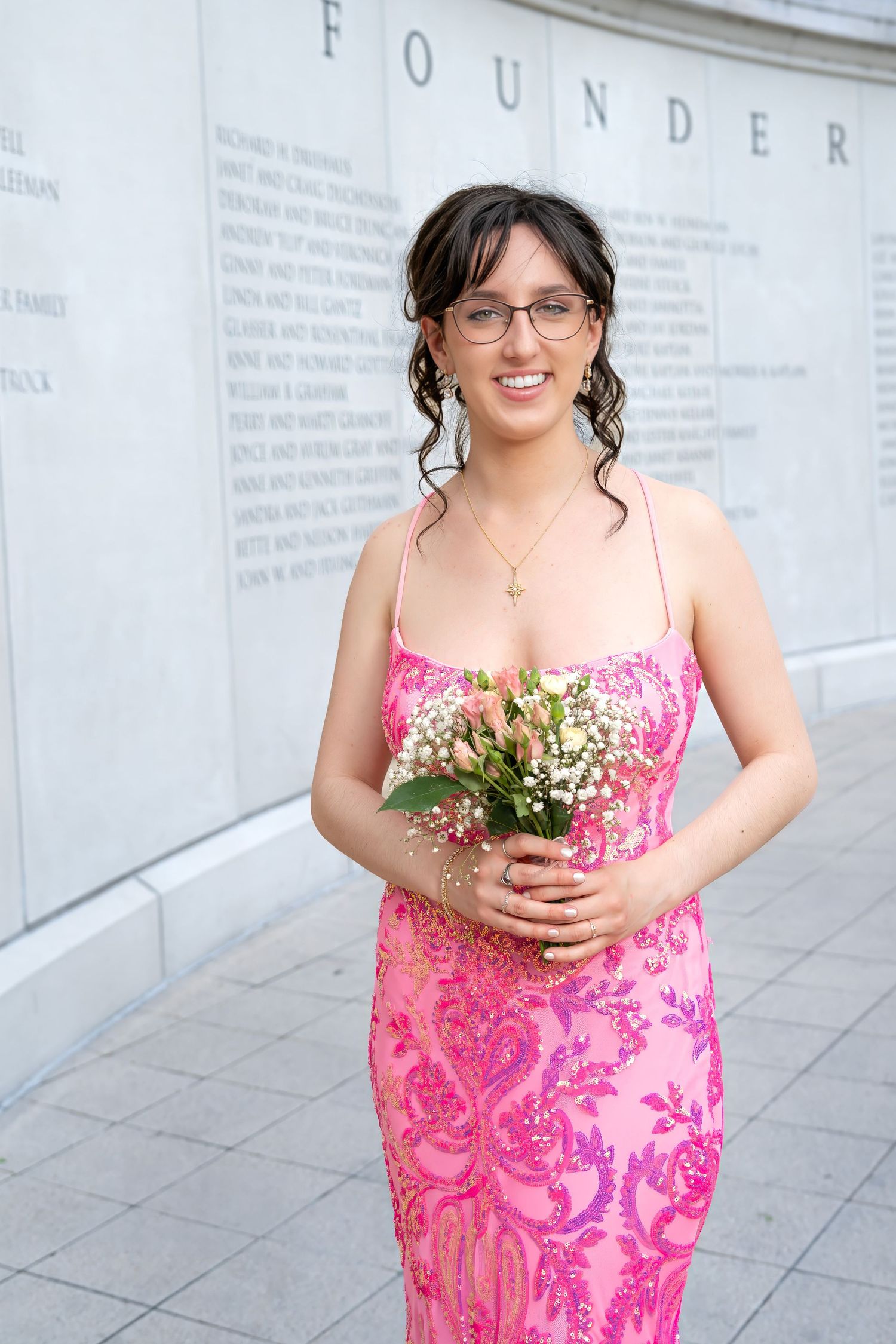 Prom portrait in a pink floral dress holding a bouquet