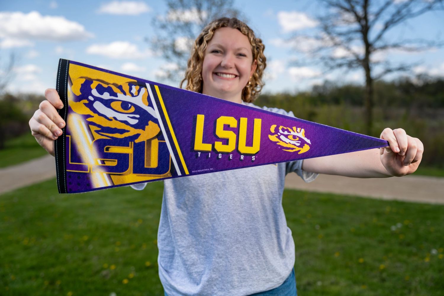 High school senior holding a college pennant, graduation announcement photo