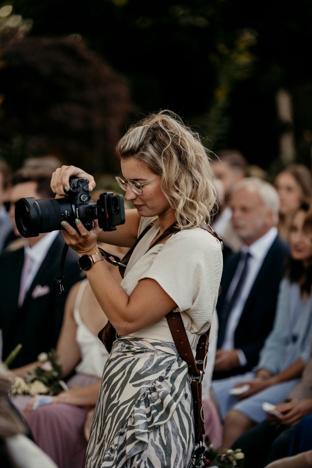 Wedding photographer in action capturing ceremony moments with professional camera equipment.