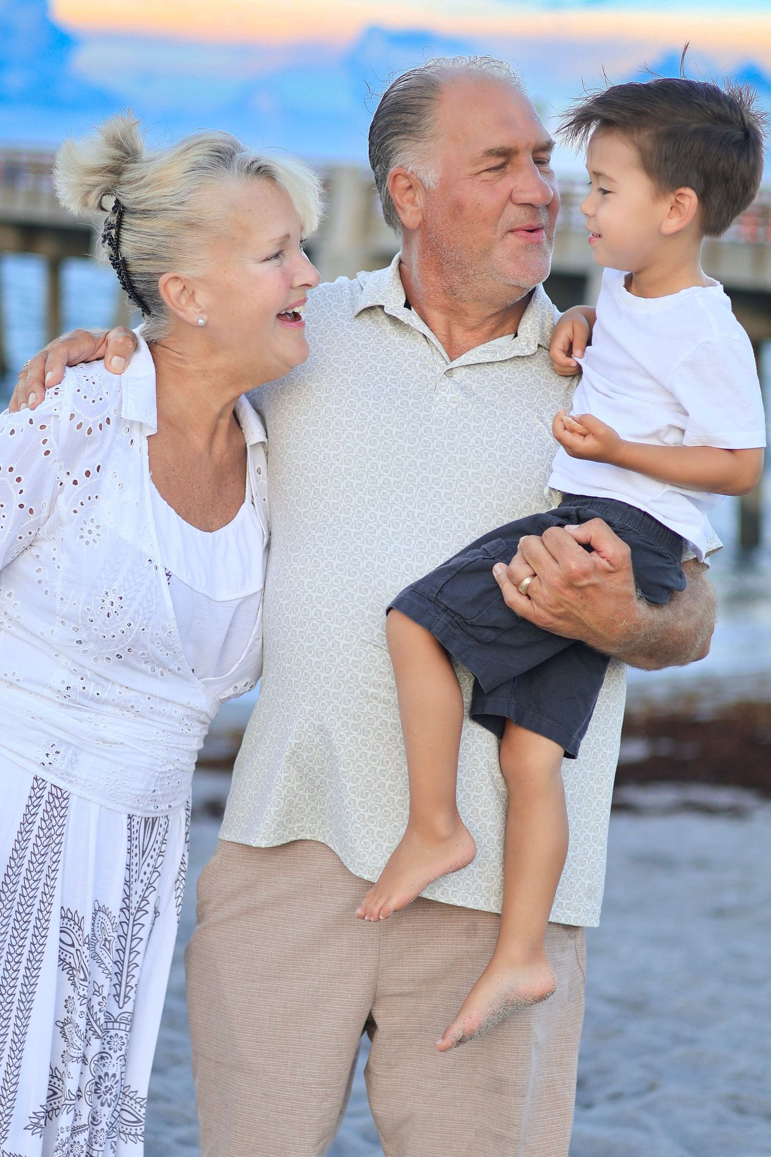 grandpa holding grandchild for family photoshoot on the beach near orlando, florida