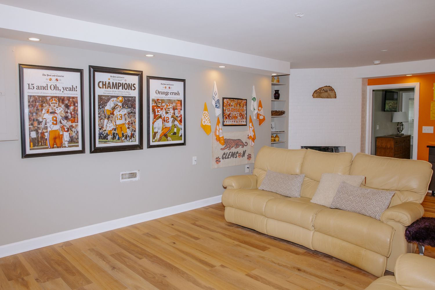 Basement rec room with leather recliner sofa and framed Tennessee Volunteers championship memorabilia.