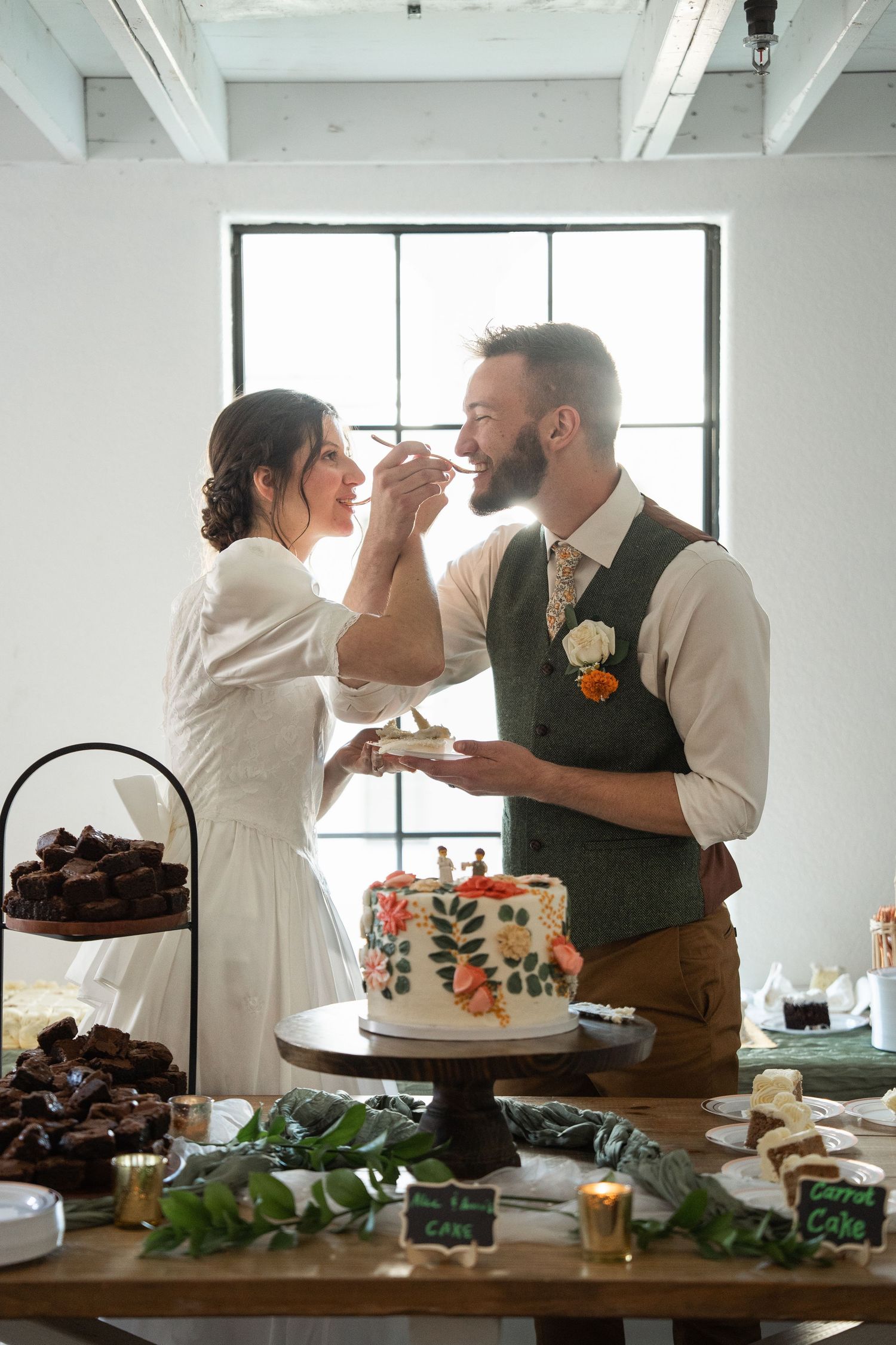 ©AnnaVonRiesenPhotography Wedding Photography | Color image of a bride & groom feeding each other the wedding cake.