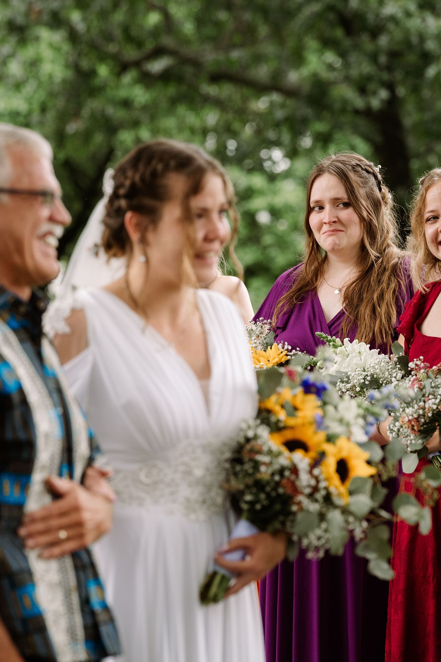©AnnaVonRiesenPhotography Wedding Photography | Color image of a bridesmaid crying as the bride & her father make it to the groom.