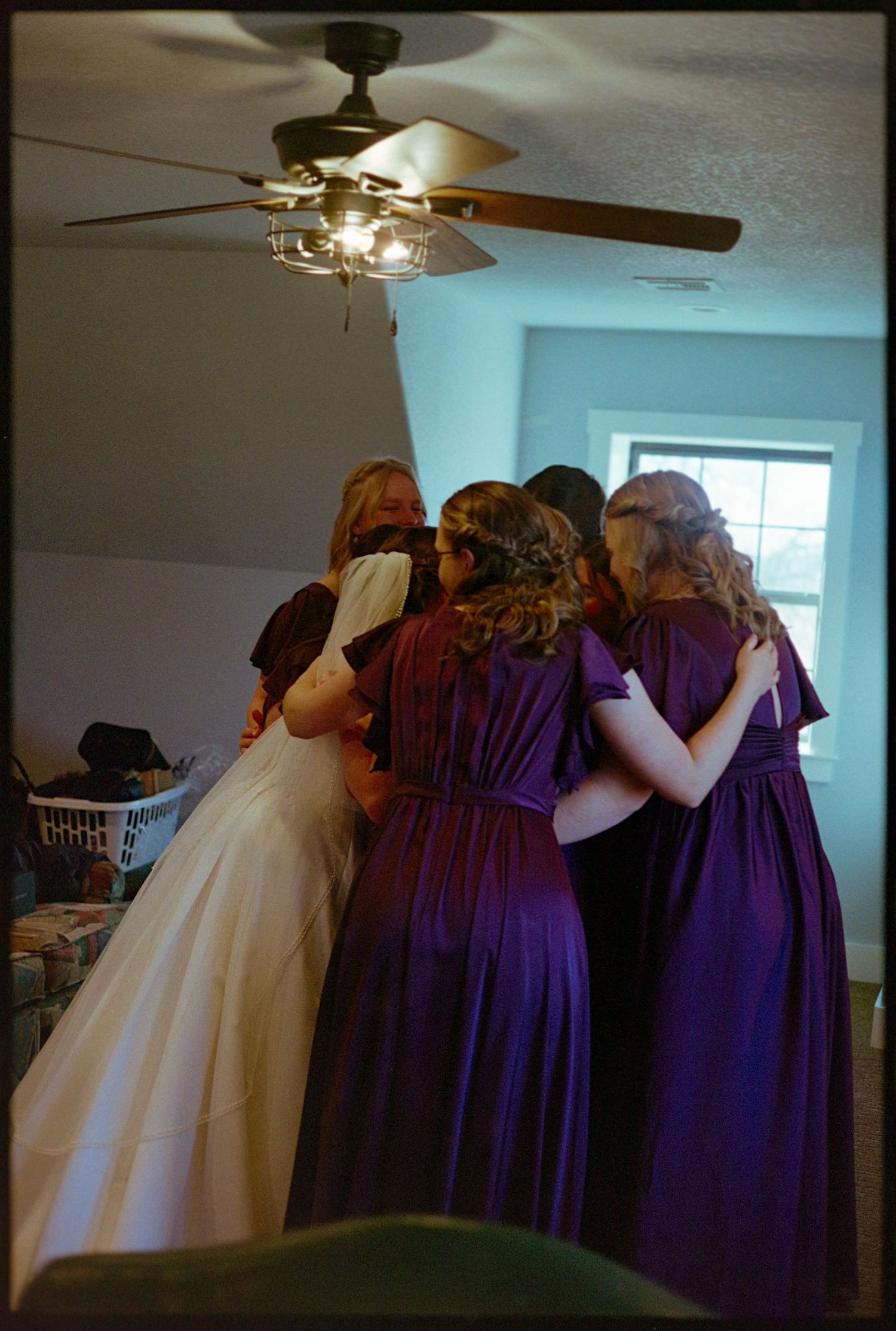 Color image of the bride hugging her bridesmaids.