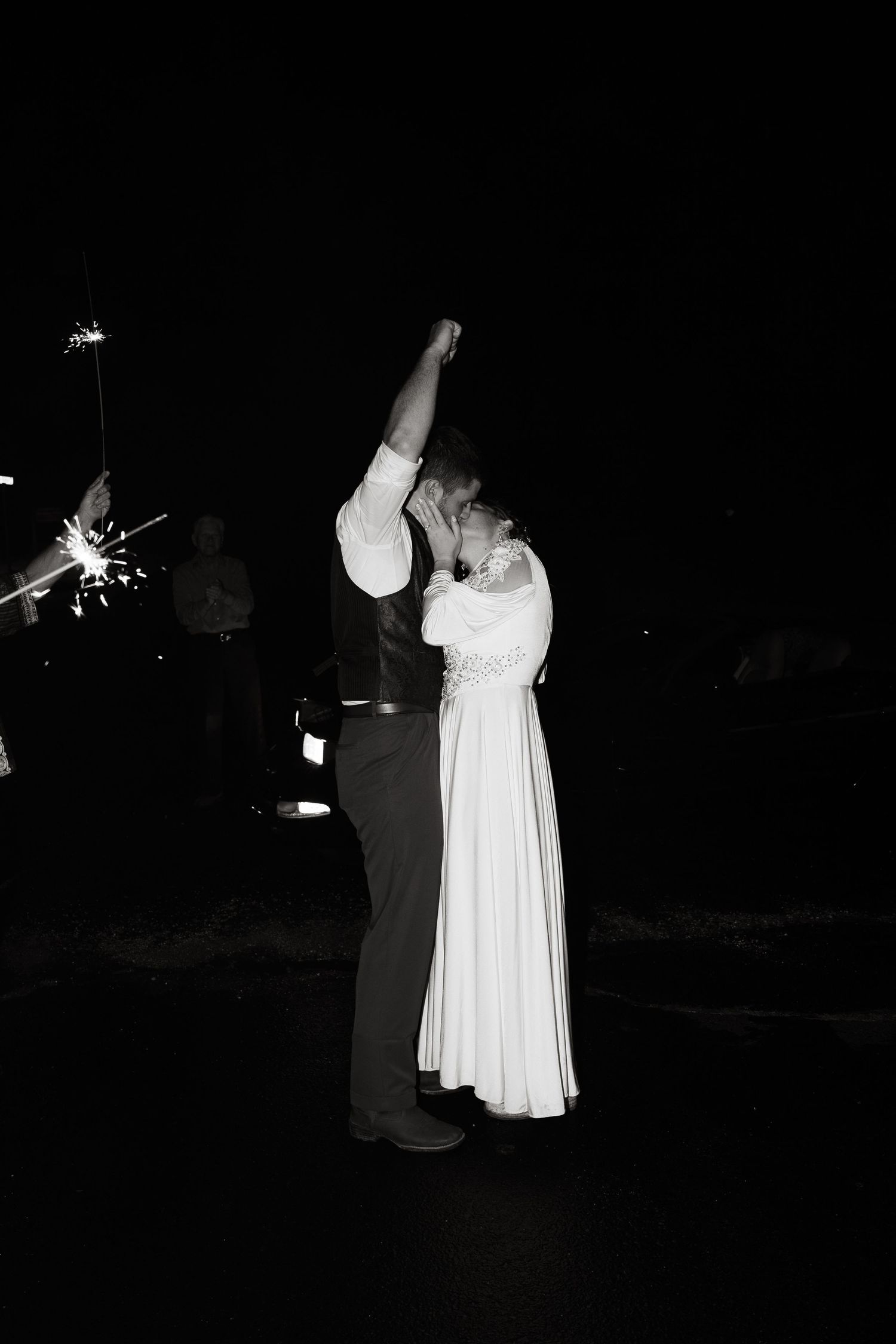 ©AnnaVonRiesenPhotography Wedding Photography | B&W image of the groom pumping his fist in the air as he kisses his wife.