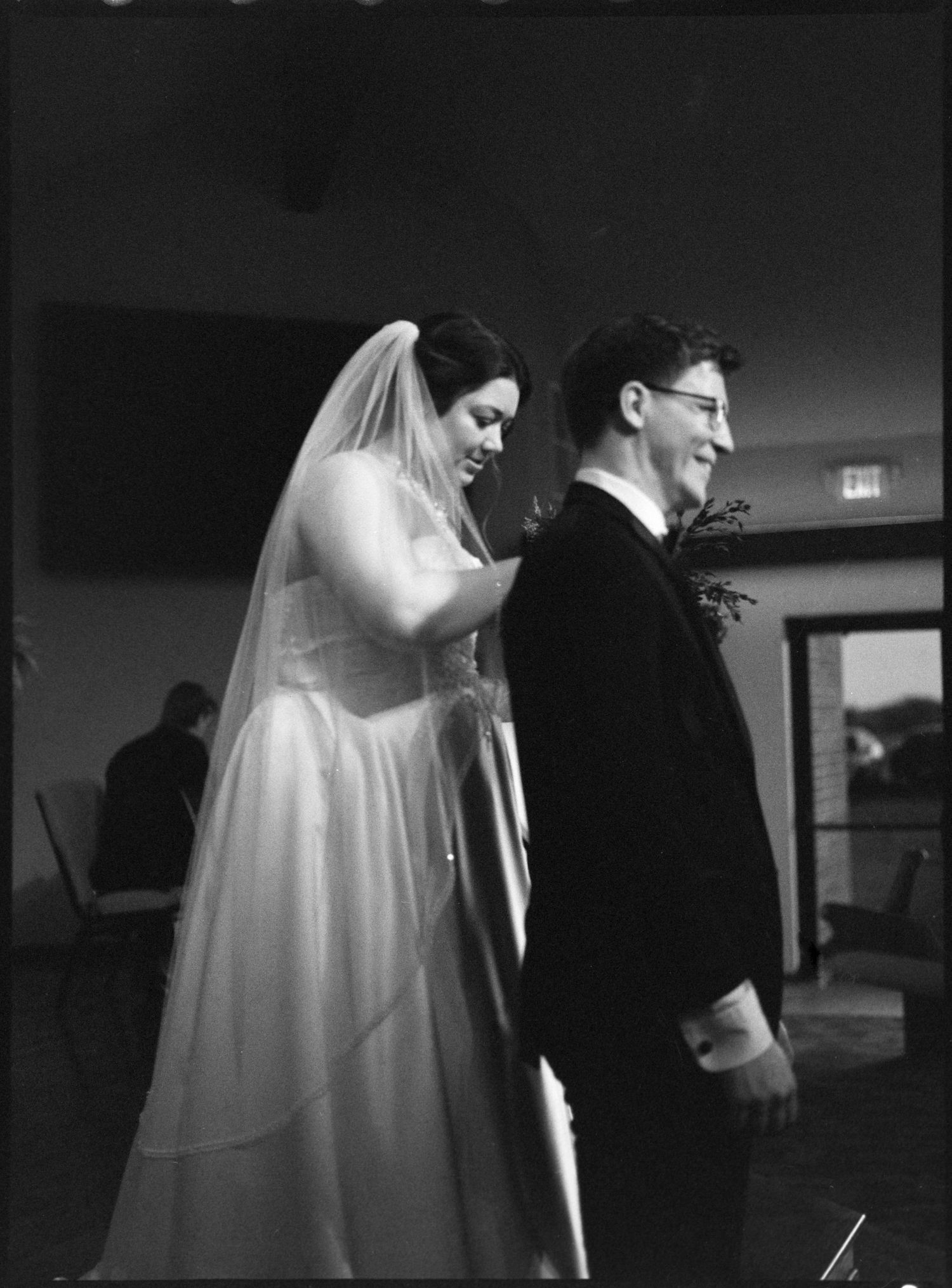 ©AnnaVonRiesenPhotography Wedding Photography | Film B&W image of a bride smiling over her groom's shoulder.