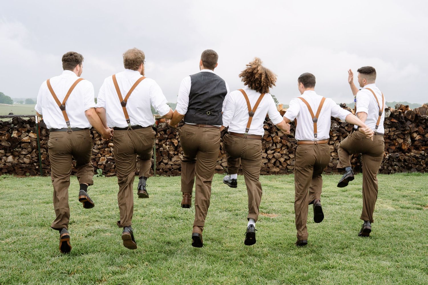 ©AnnaVonRiesenPhotography Wedding Photography | Color image of the groomsmen skipping and jumping.