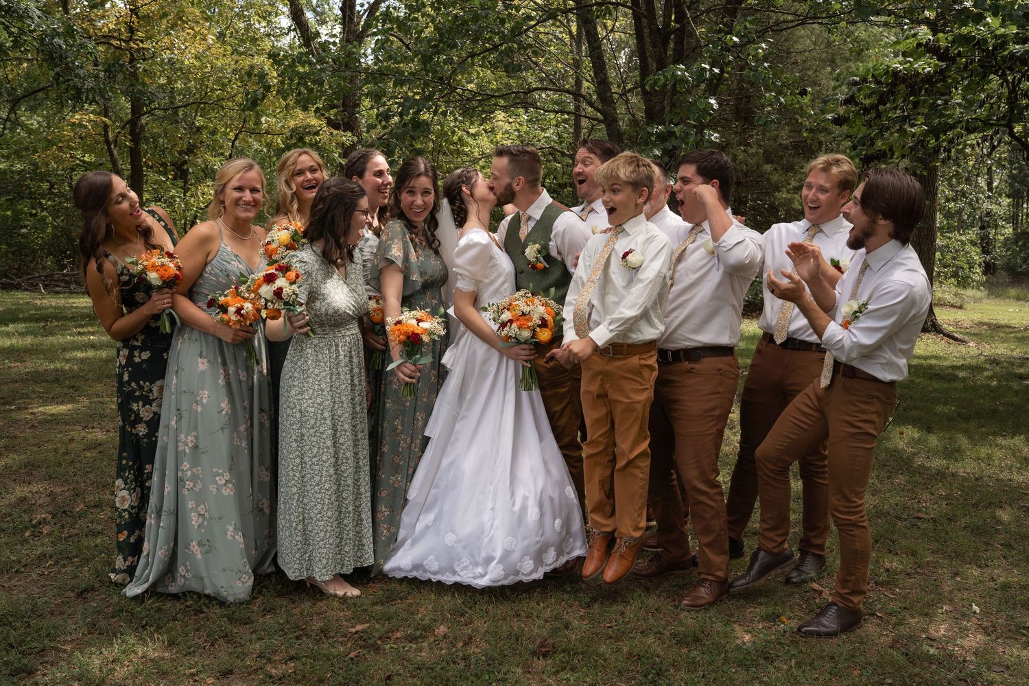 ©AnnaVonRiesenPhotography Wedding Photography | Color image of the bridal party cheering as the bride & groom kiss.