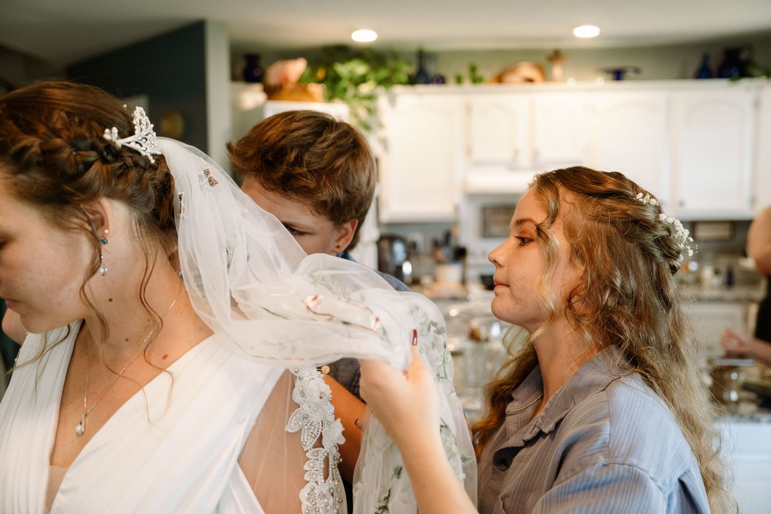 ©AnnaVonRiesenPhotography Wedding Photography | Color image of the bride's sisters helping her get ready.