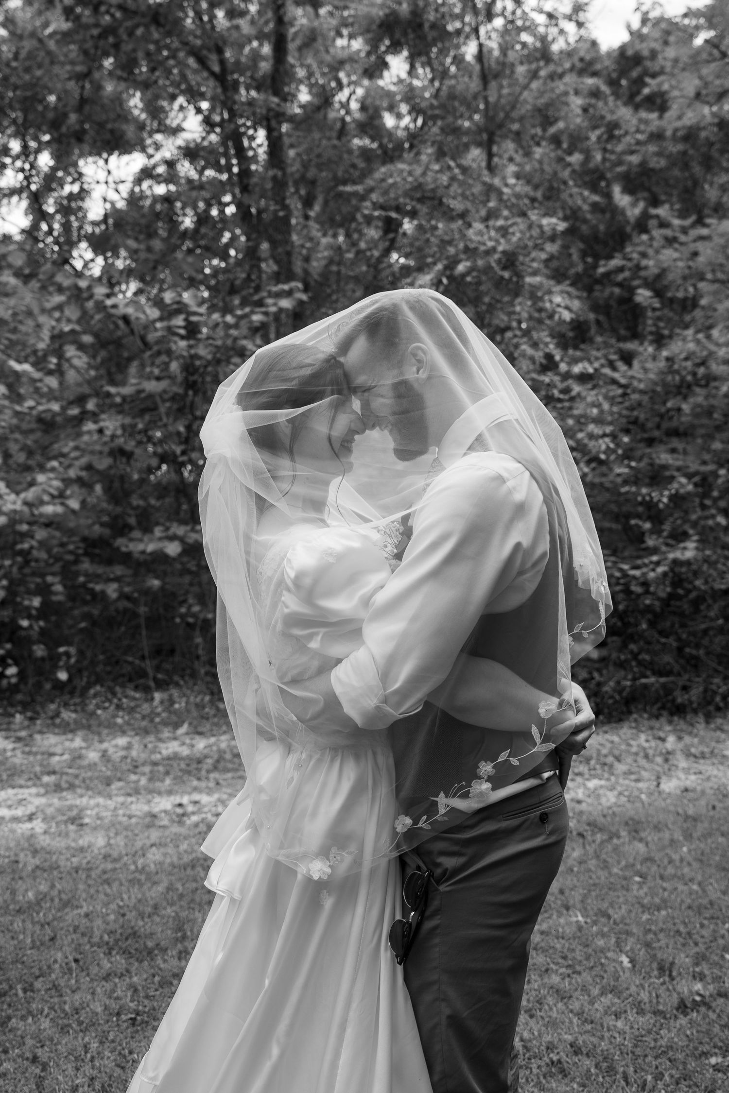 ©AnnaVonRiesenPhotography Wedding Photography | B&W image of the bride & groom touching foreheads and smiling under the veil.